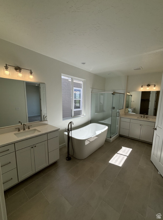 Bathroom with tile flooring, vanity, and independent shower and bath