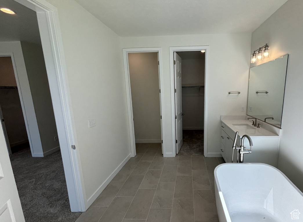 Bathroom featuring tile flooring, vanity, and a bathing tub