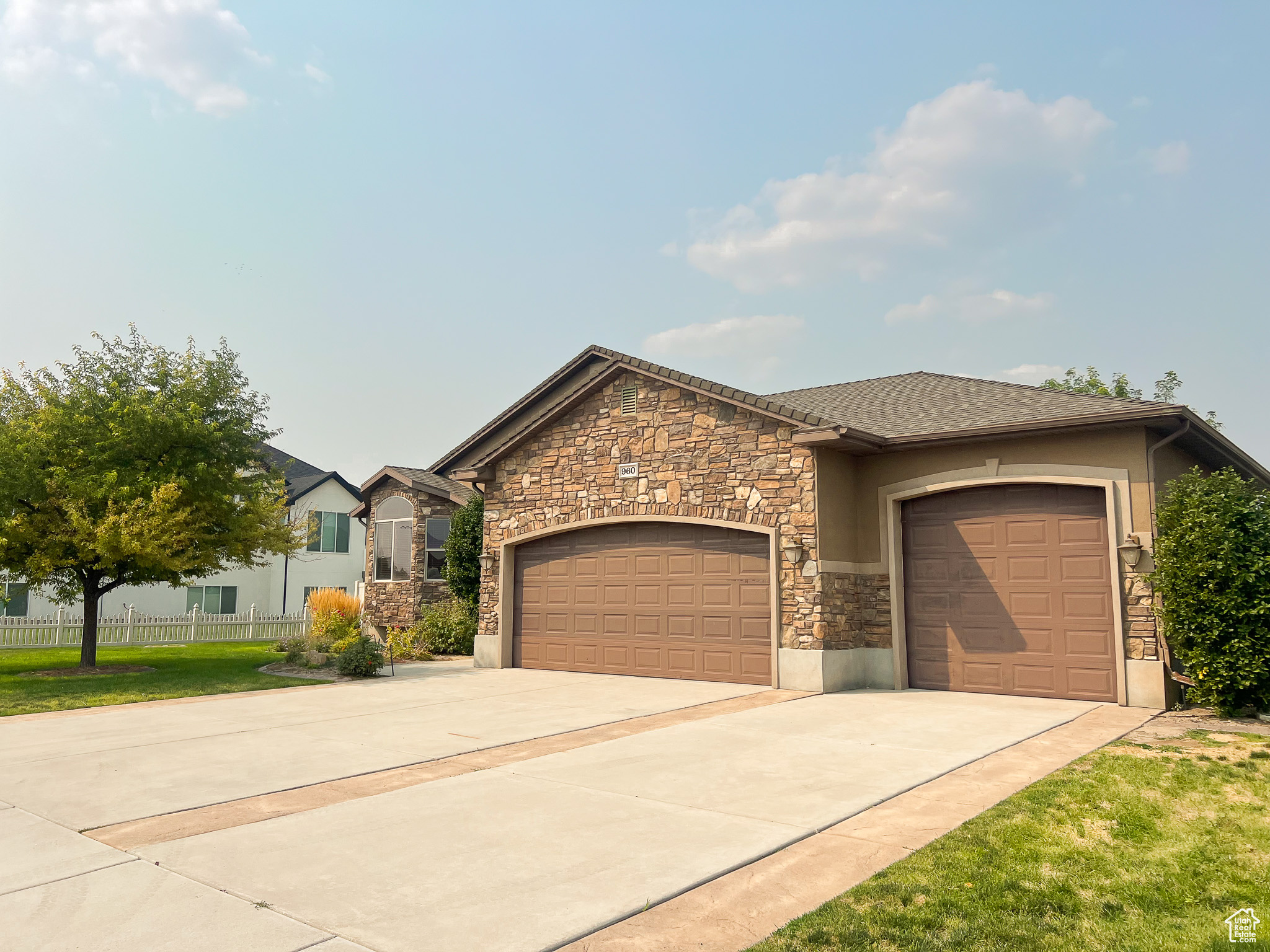 View of front facade featuring a garage and a front lawn