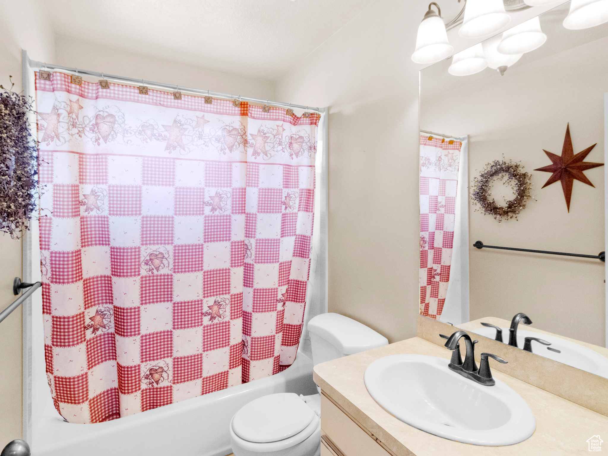 Full bathroom featuring vanity, toilet, and shower / bath combination with curtain