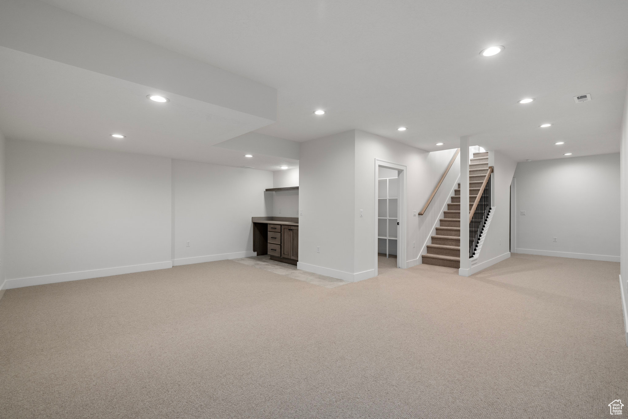 Basement featuring light colored carpet