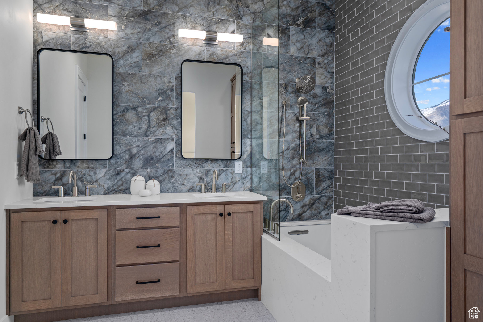 Bathroom with shower with separate bathtub, tile walls, large vanity, and double sink