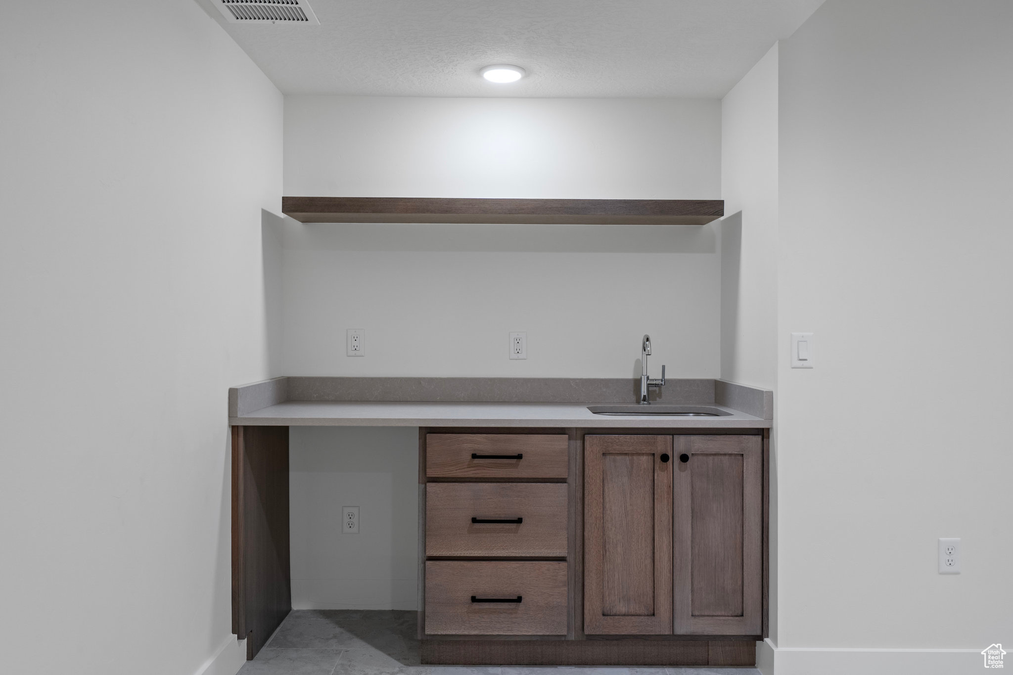 Bar featuring sink and light tile floors