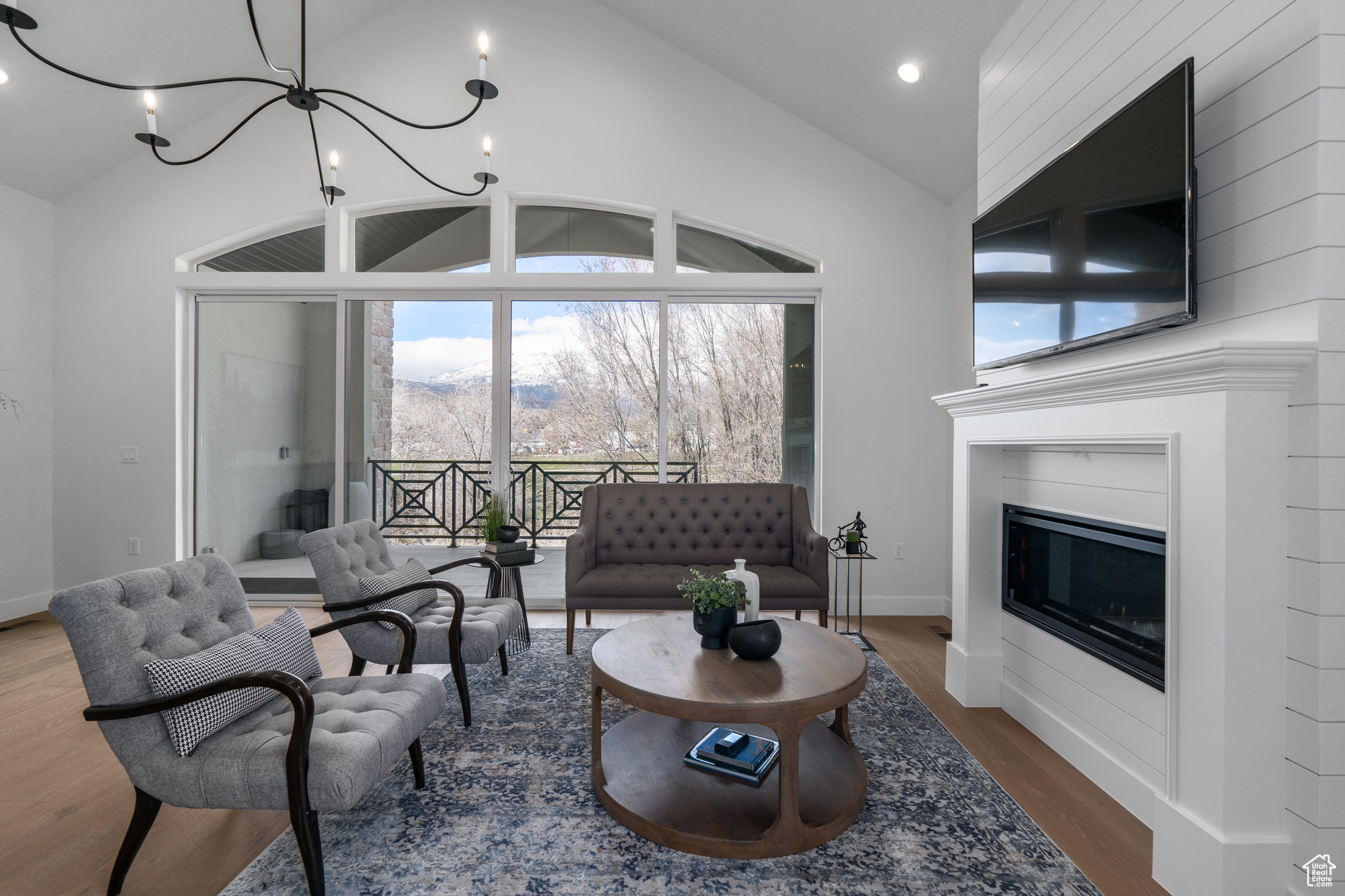 Living room featuring an inviting chandelier, dark hardwood / wood-style flooring, and high vaulted ceiling