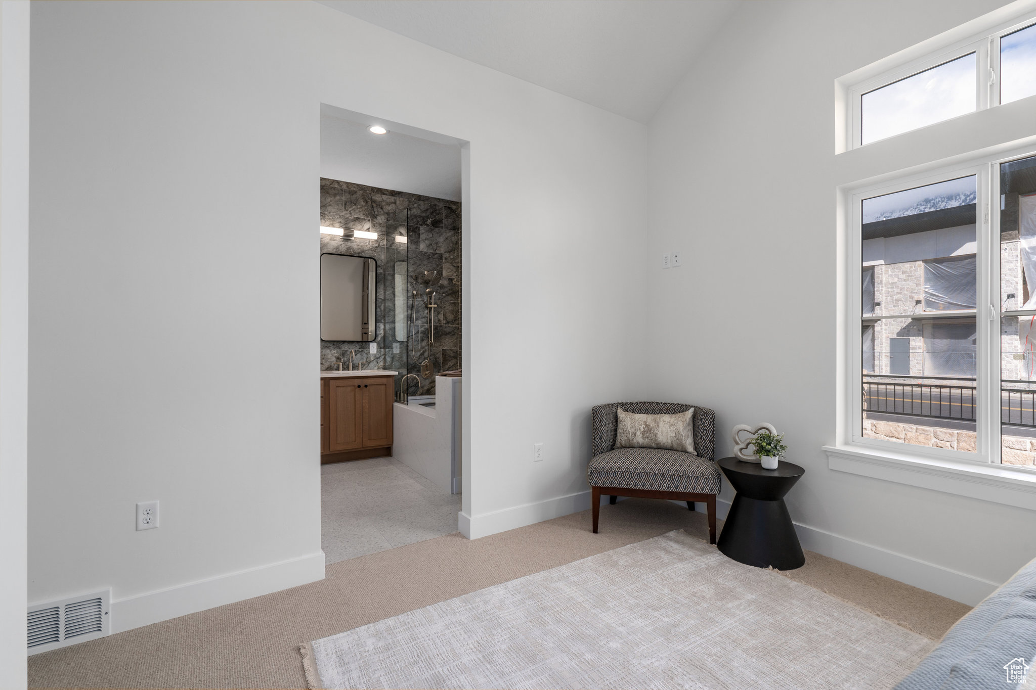 Sitting area with lofted ceiling and light carpet