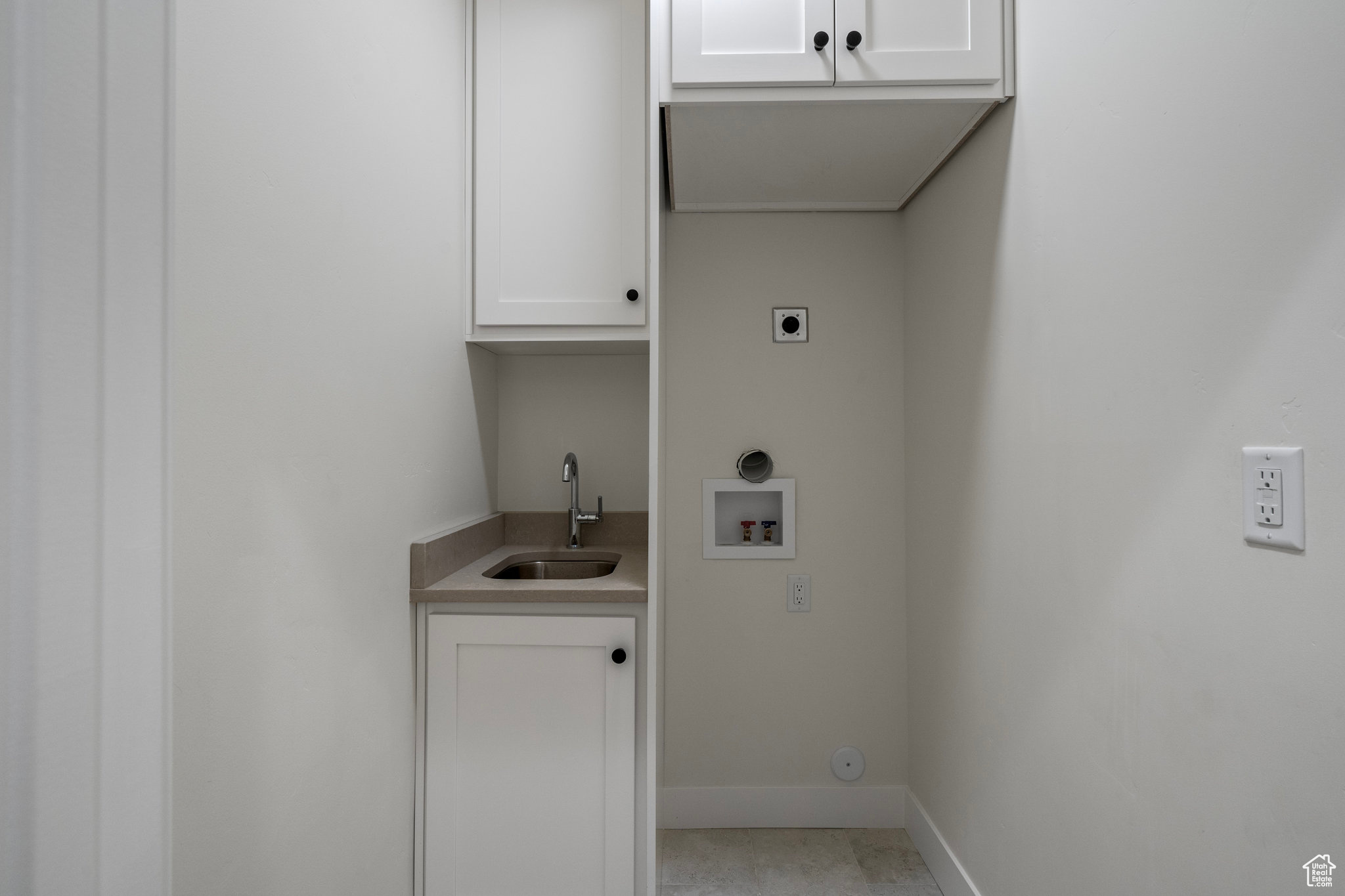 Laundry area with sink, washer hookup, hookup for a gas dryer, electric dryer hookup, and cabinets