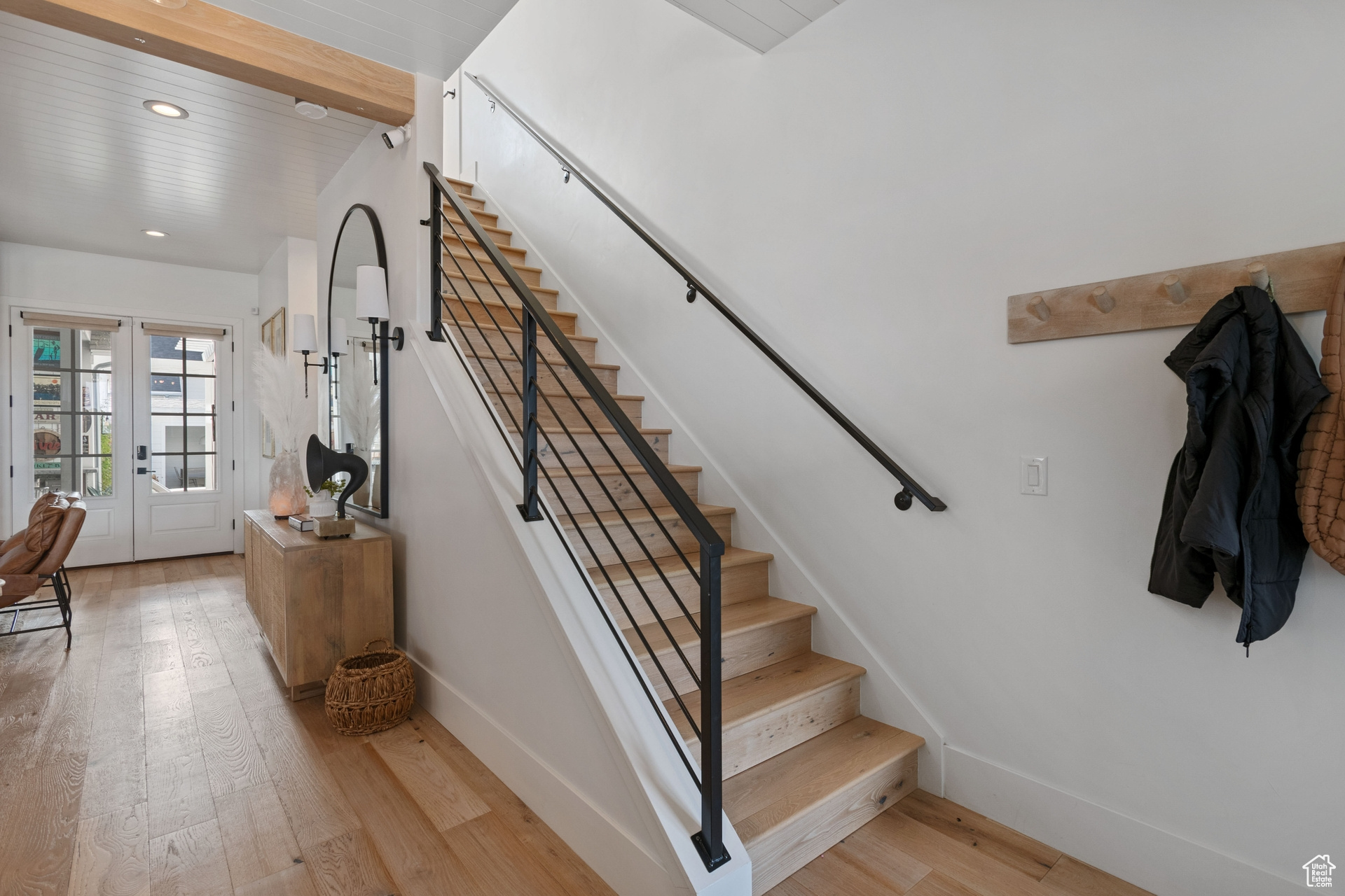 Stairs featuring light hardwood / wood-style flooring, french doors, and beamed ceiling