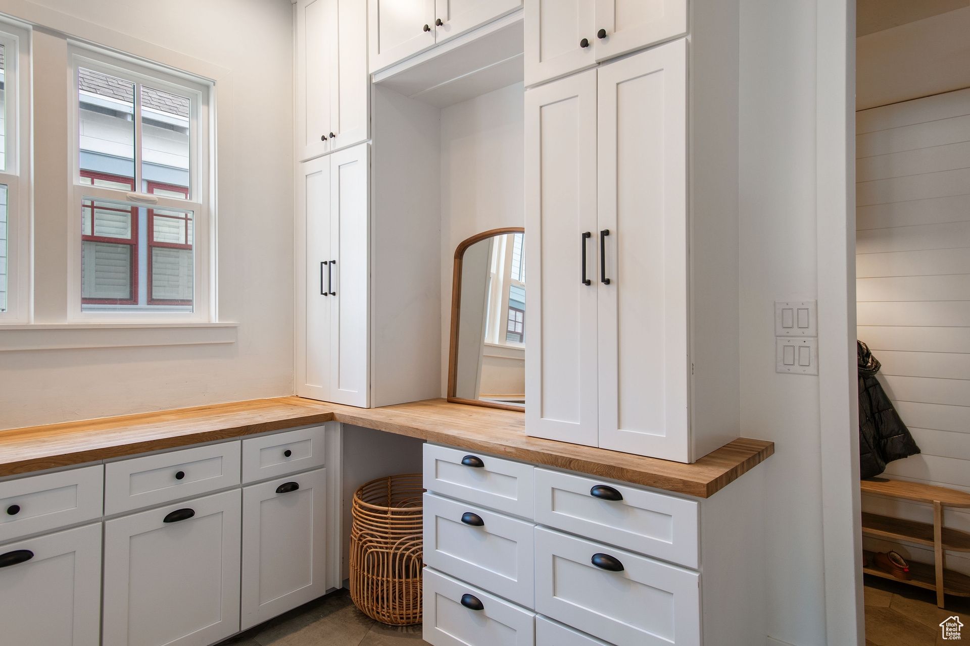 Laundry white cabinetry, butcher block countertops, and dark tile floors