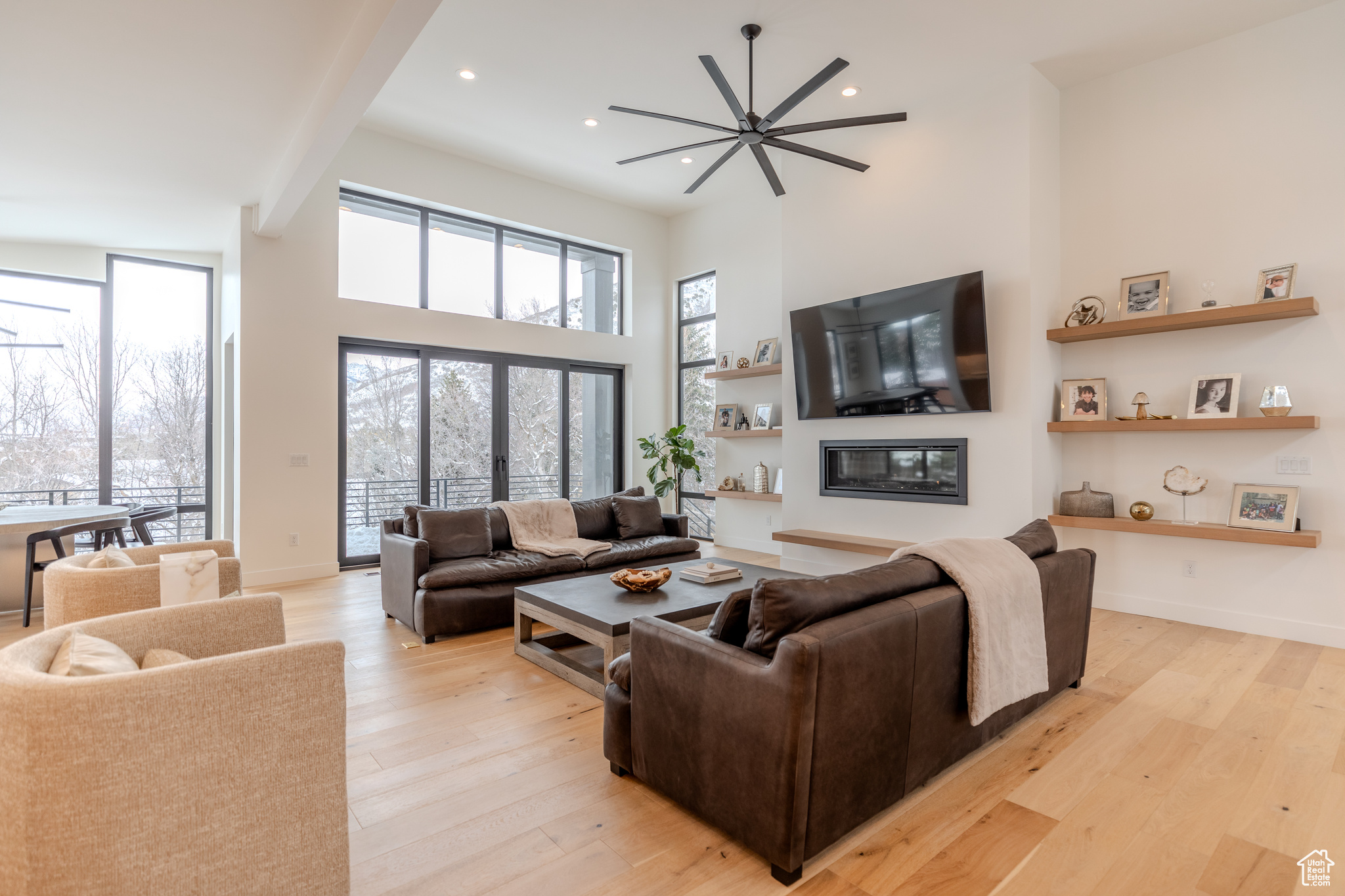 Living room with a wealth of natural light, light hardwood / wood-style floors, and ceiling fan