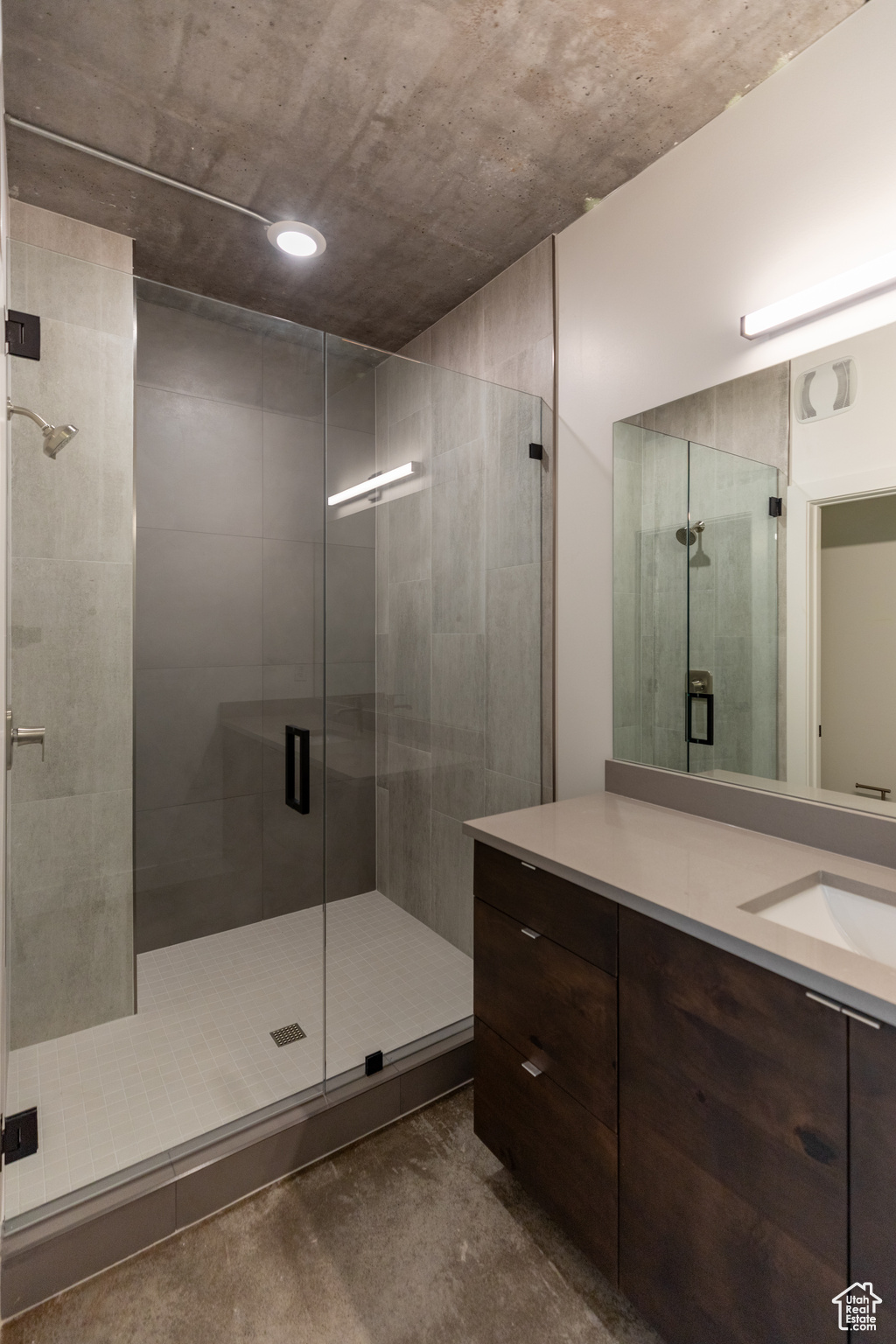 Bathroom featuring a shower with door and vanity