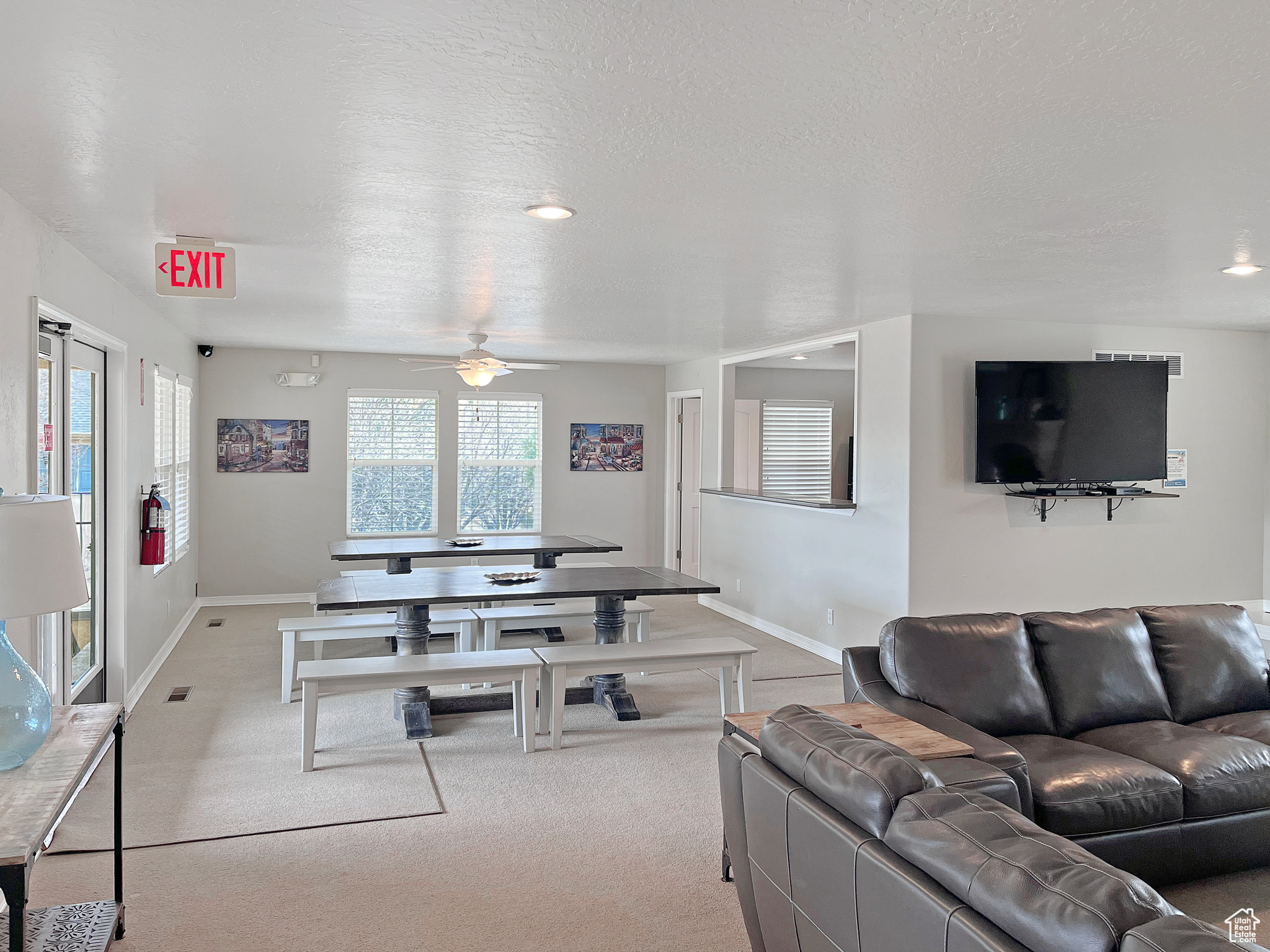 Gathering or eating area in the community  center boasting a large tv and fireplace, next to kitchen and game area