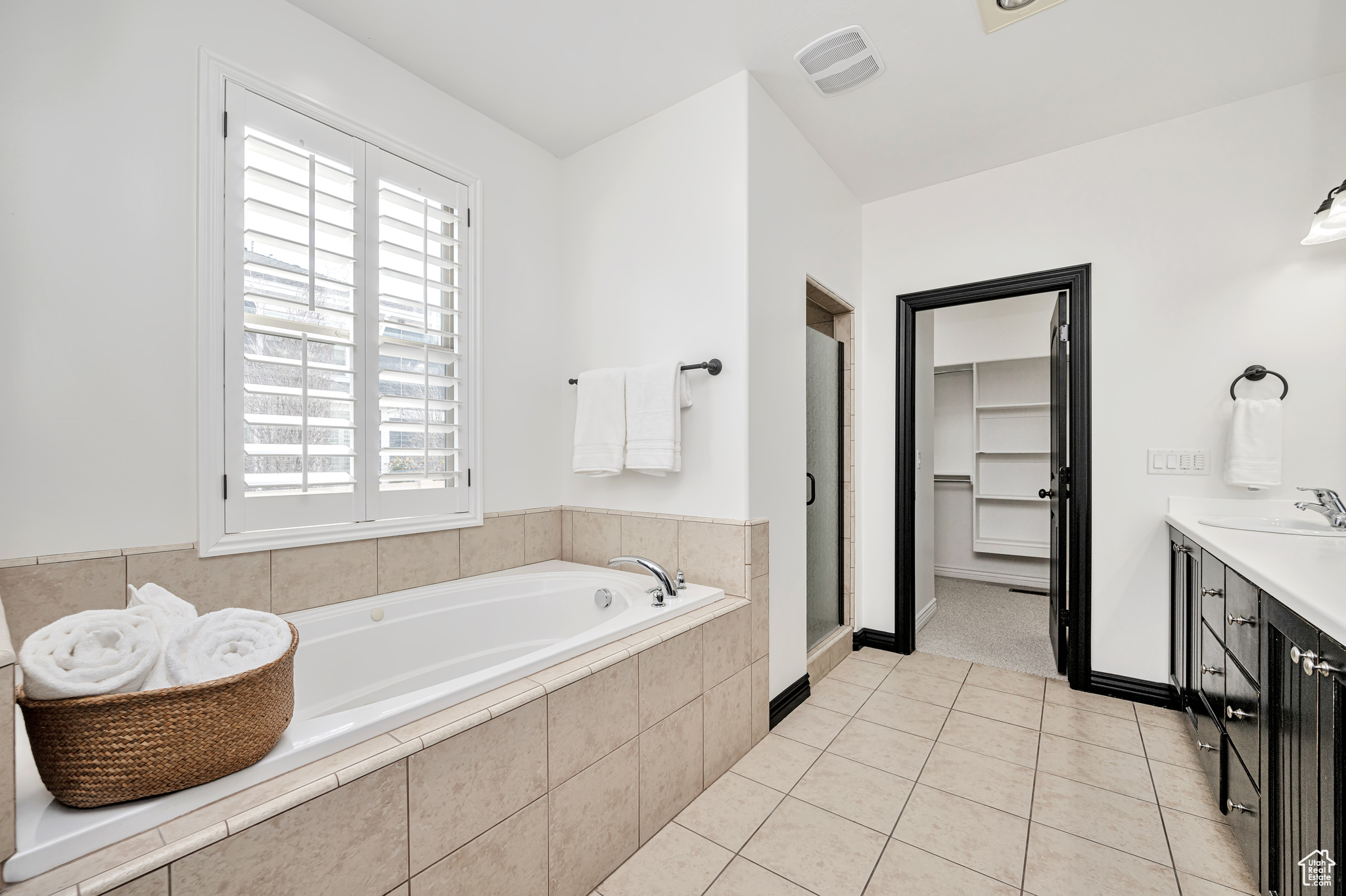 Bathroom 1 with tile floors, a wealth of natural light, vanity and jetted tub