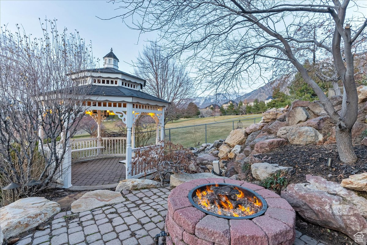 View of terrace with a gazebo, a mountain view, and an outdoor fire pit