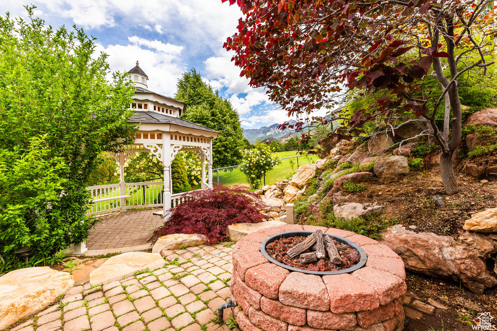 View of terrace with a gazebo and a fire pit
