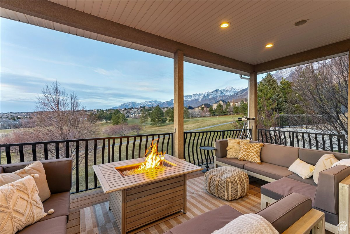 Deck featuring an outdoor living space with a fire pit and a mountain view