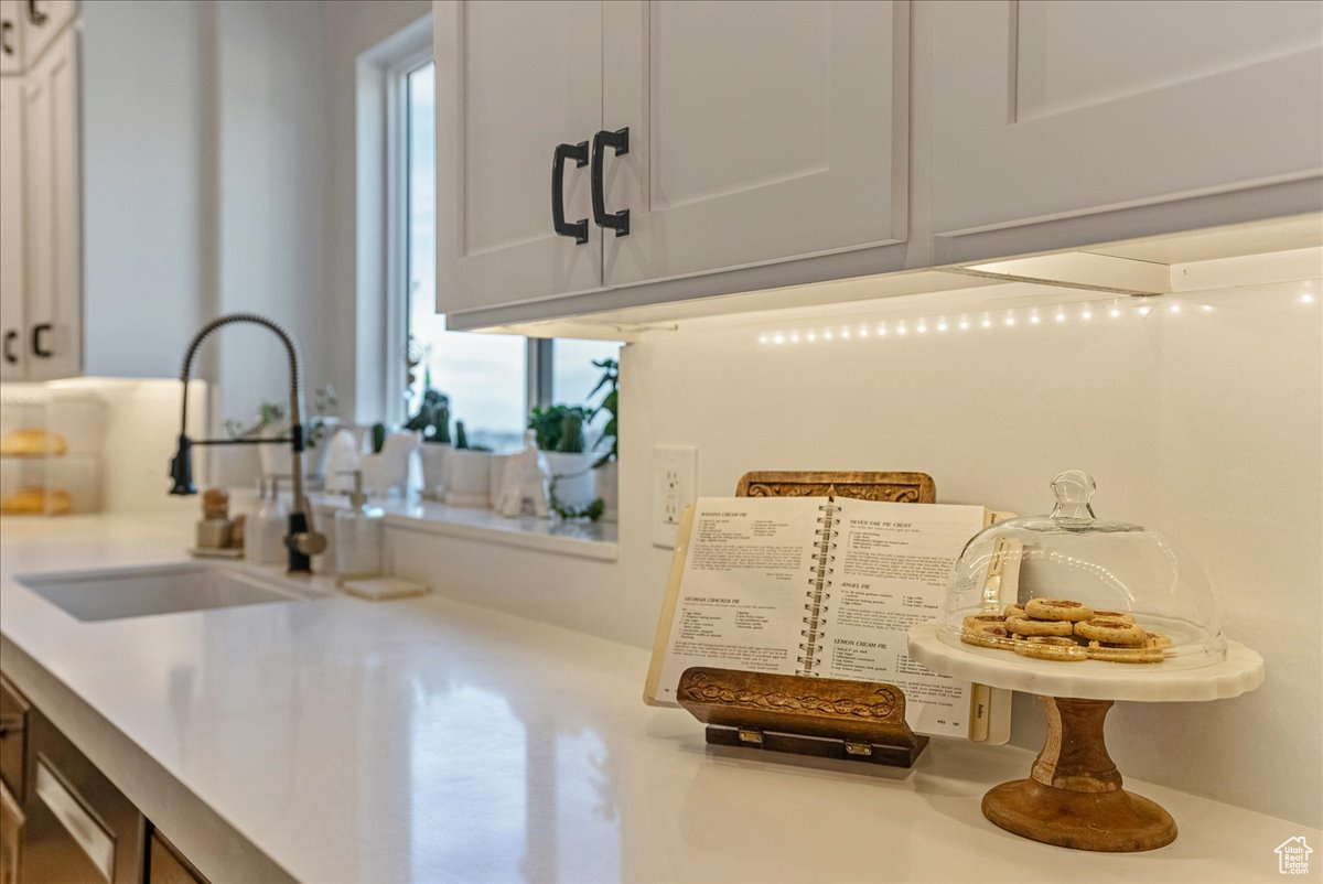 Kitchen with white cabinetry, a healthy amount of sunlight, and sink