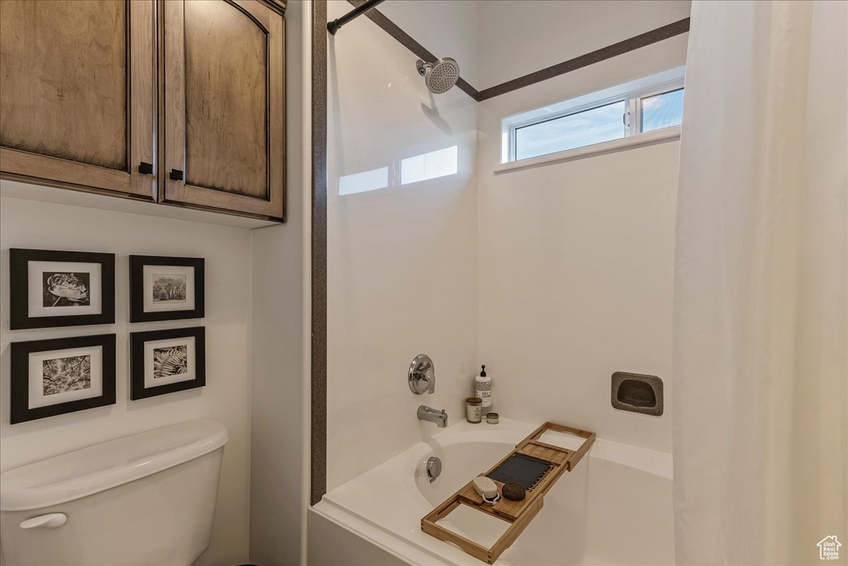 Bathroom with shower / washtub combination and toilet