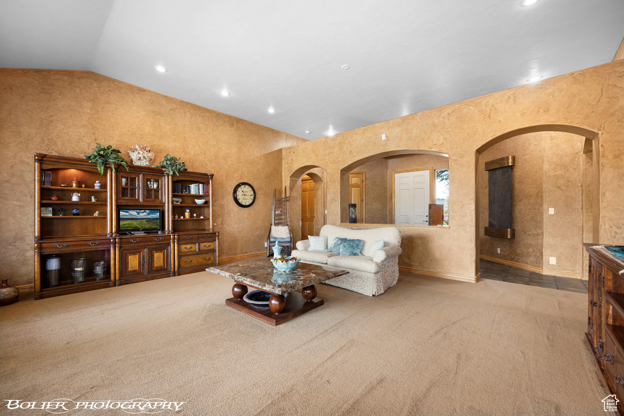 Carpeted living room with lofted ceiling