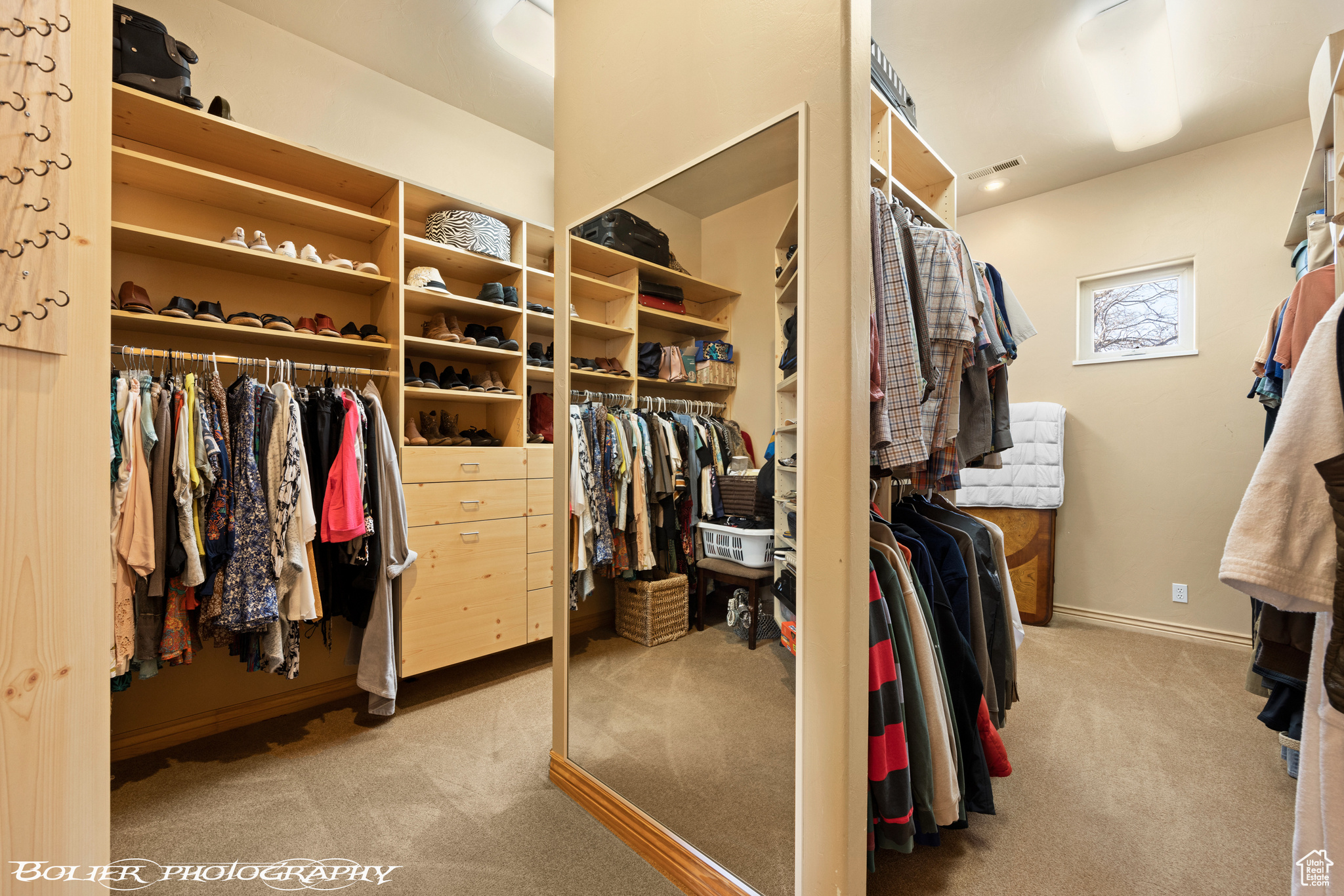 Walk in closet with light colored carpet