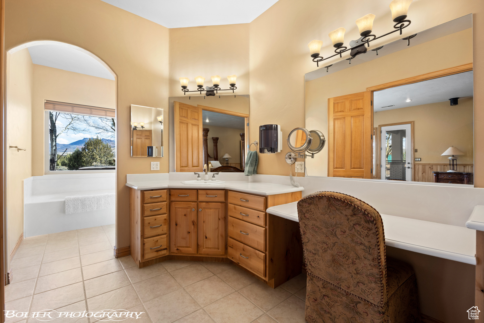 Bathroom with vanity, a bath, and tile floors