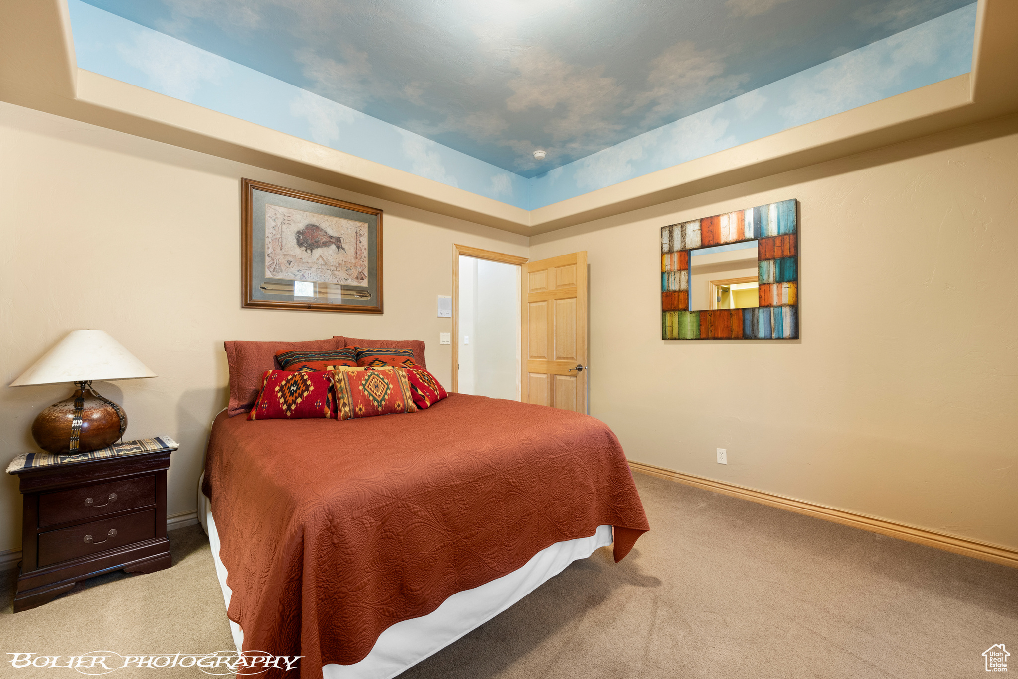 Bedroom with a tray ceiling and carpet floors