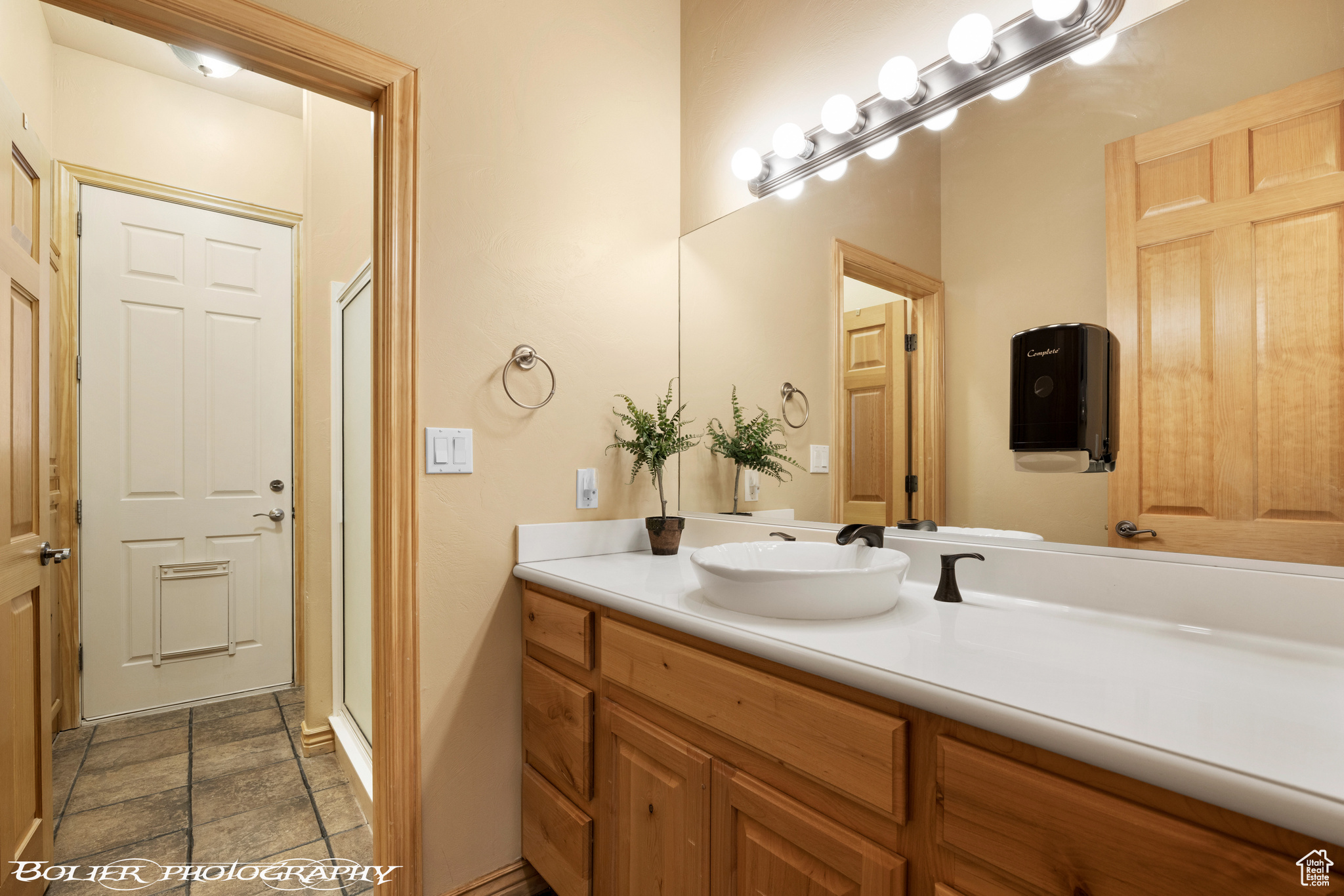 Bathroom featuring tile flooring, vanity, and walk in shower