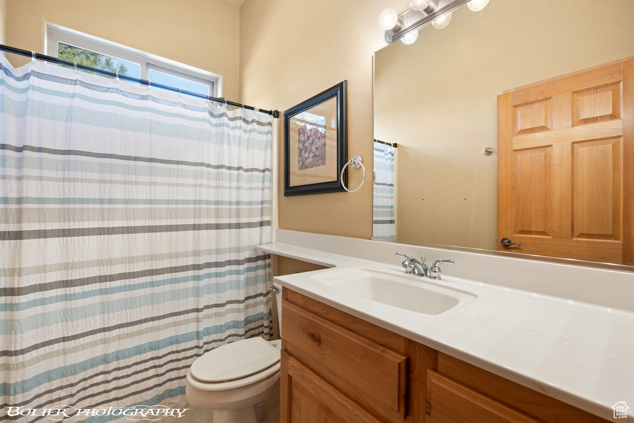 Bathroom with toilet and vanity with extensive cabinet space