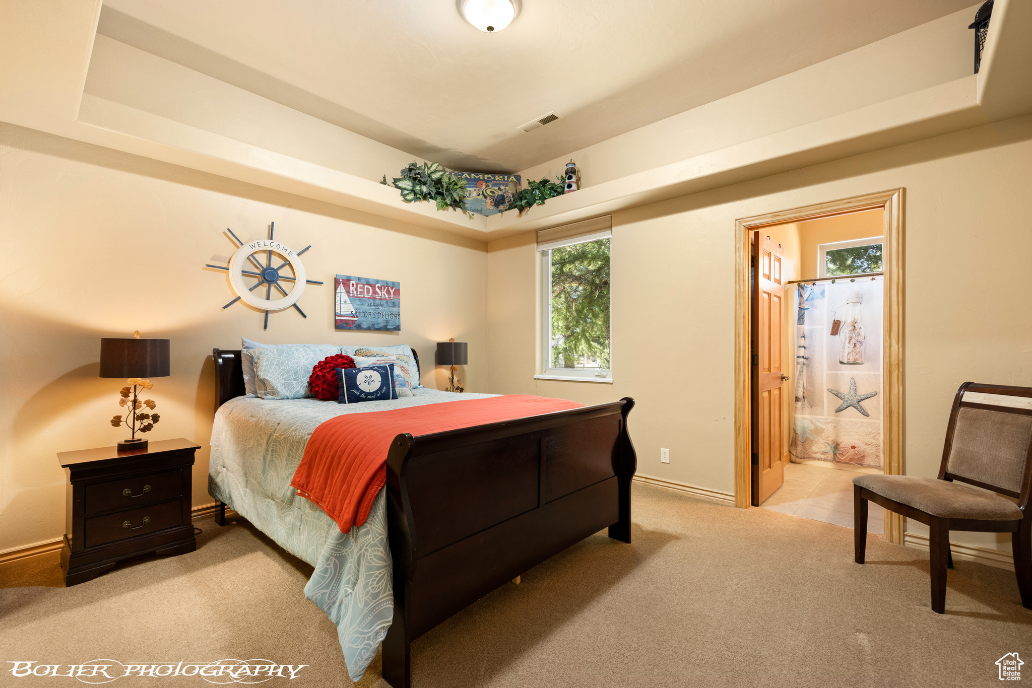 Bedroom 1 featuring connected bathroom, walk-in closet, and a tray ceiling