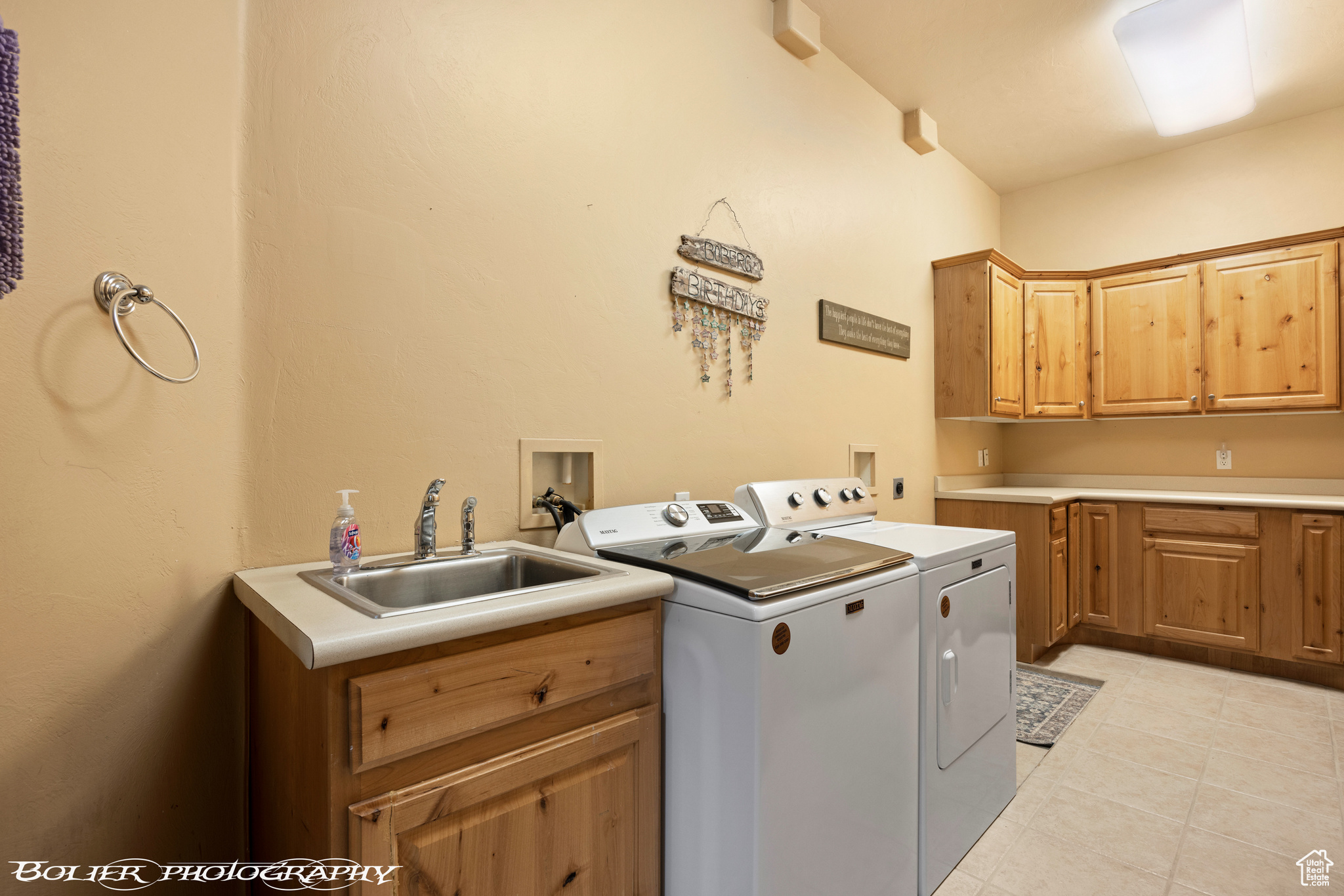 Laundry room with sink, washer and dryer, washer hookup, light tile floors, and cabinets