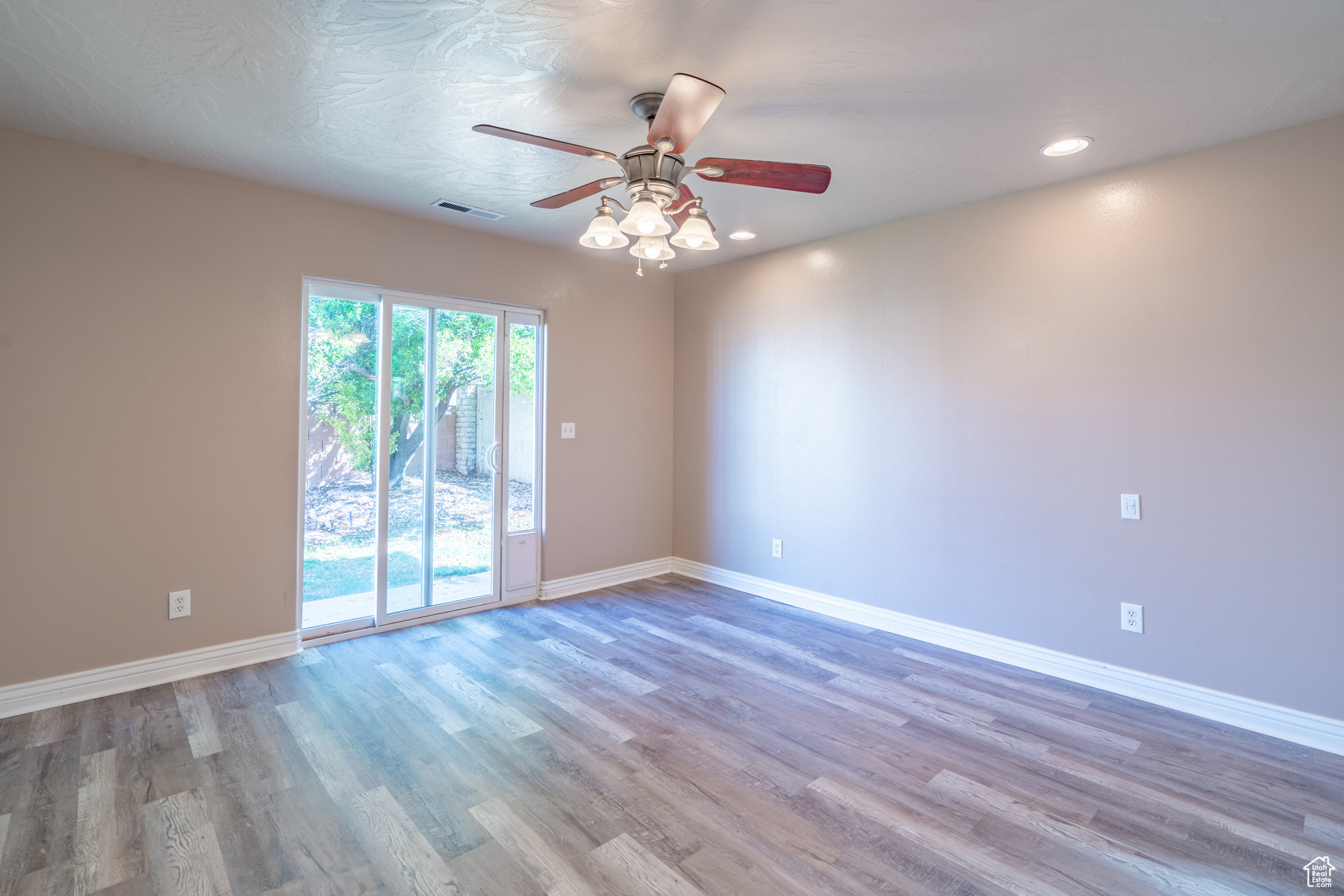 Empty room with plenty of natural light, ceiling fan, and light hardwood / wood-style flooring