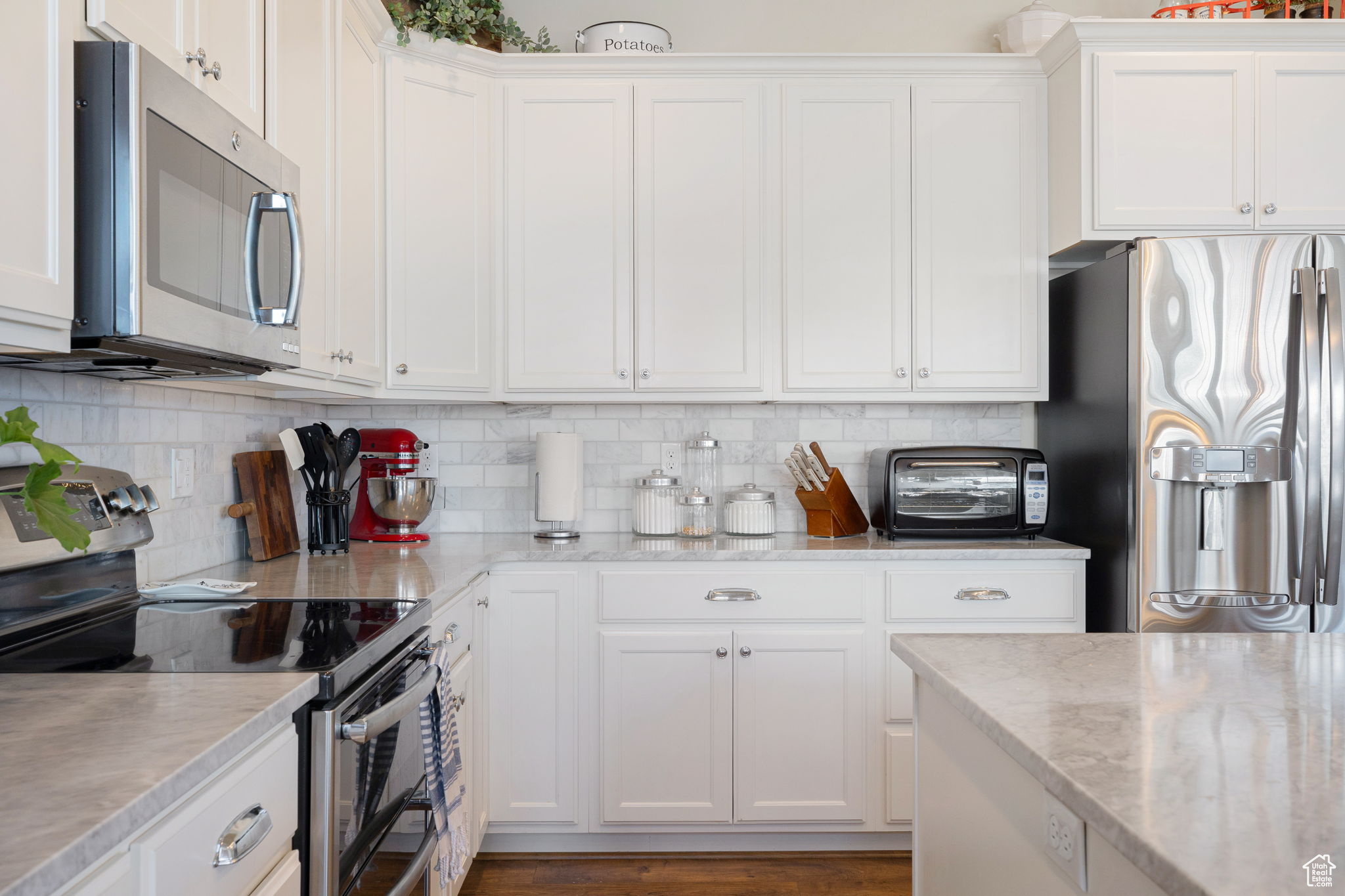 Kitchen featuring white cabinetry, tasteful backsplash, and stainless steel appliances