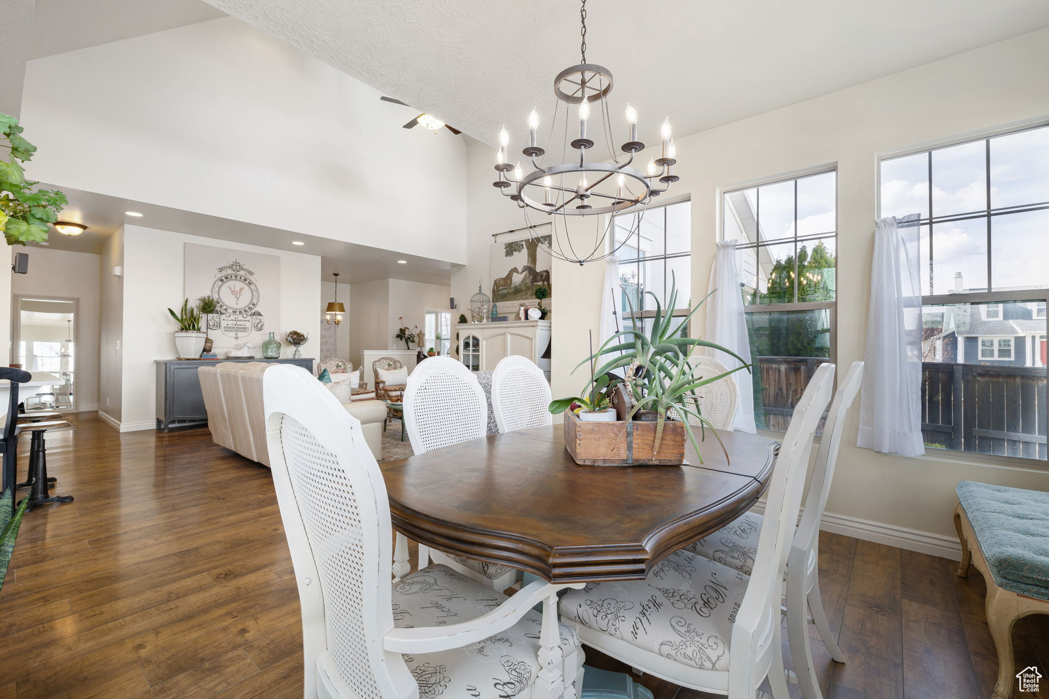 Dining area with a wealth of natural light, a notable chandelier, and dark hardwood / wood-style flooring