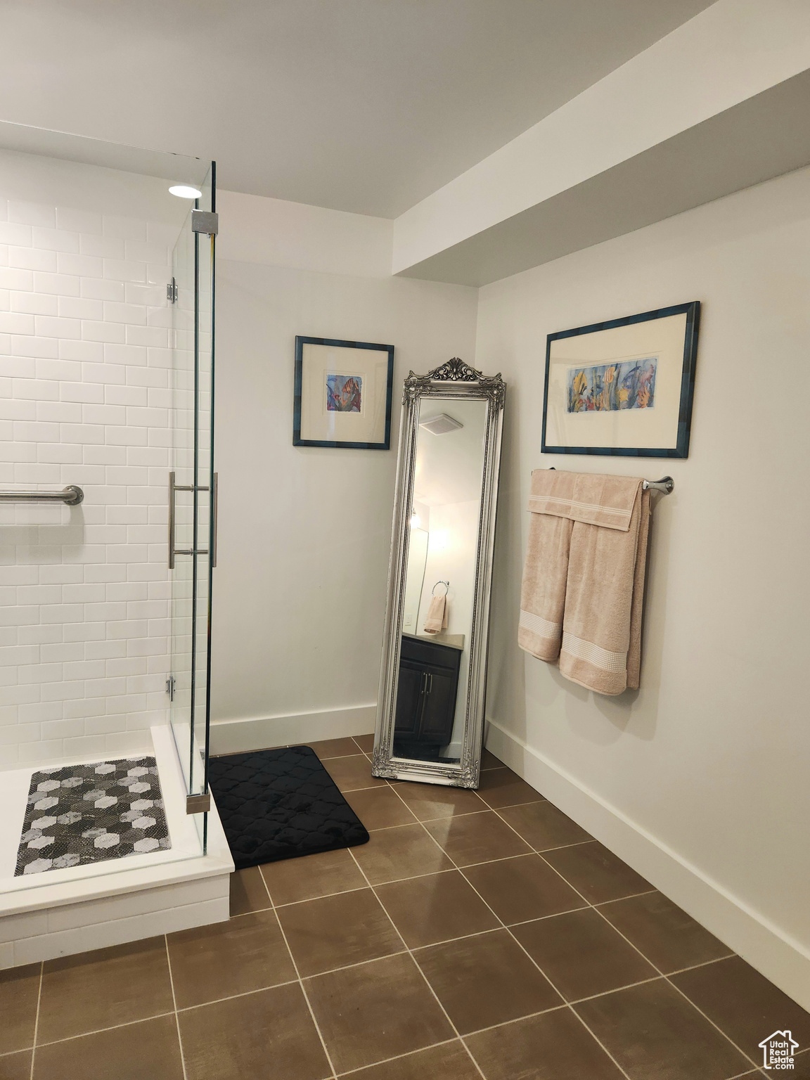 Bathroom featuring a shower with door and tile flooring