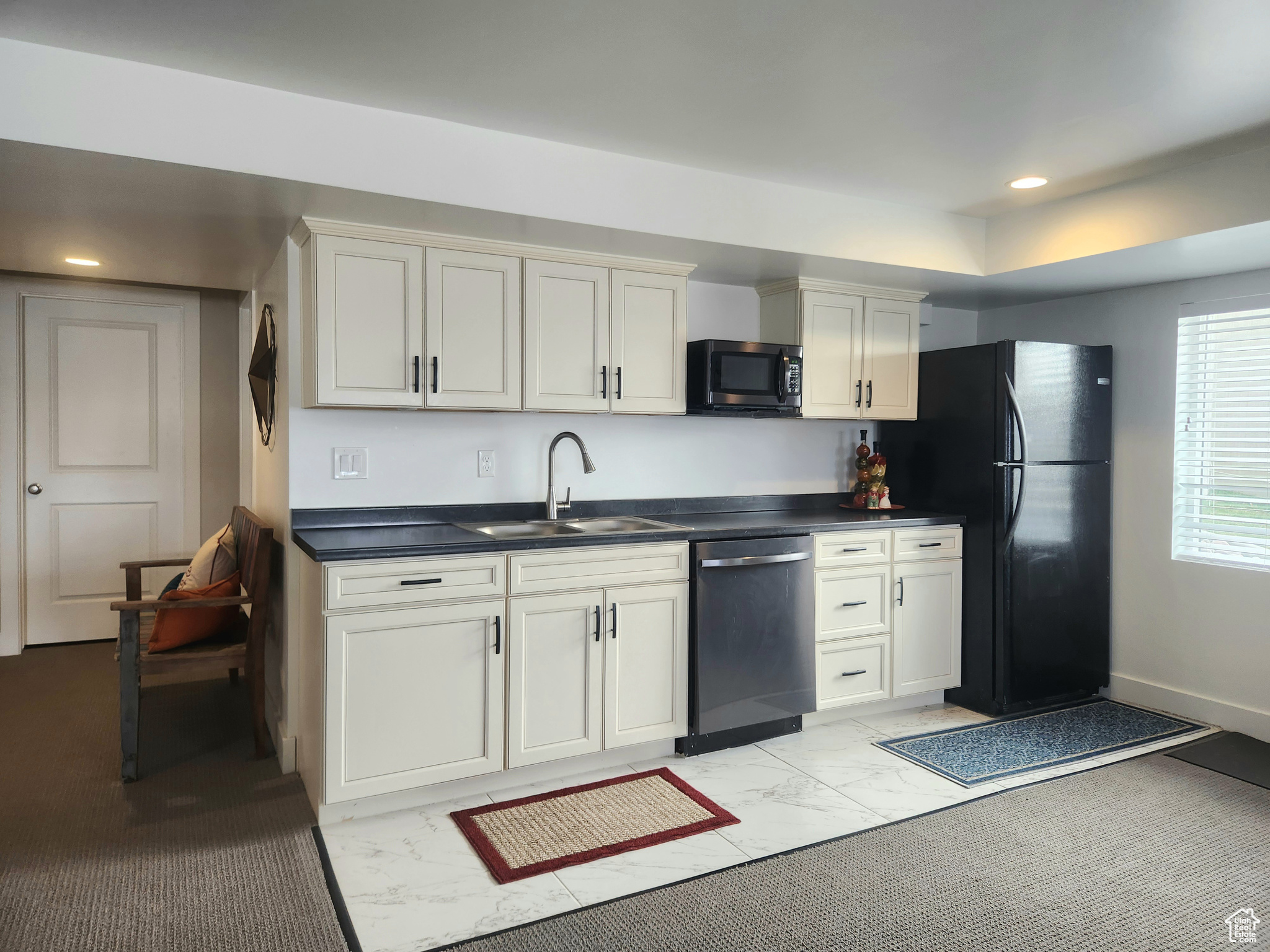 Kitchen with sink, stainless steel appliances, and light carpet
