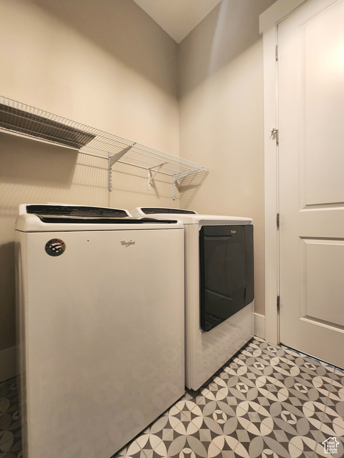 Laundry room with light tile flooring and washer and dryer