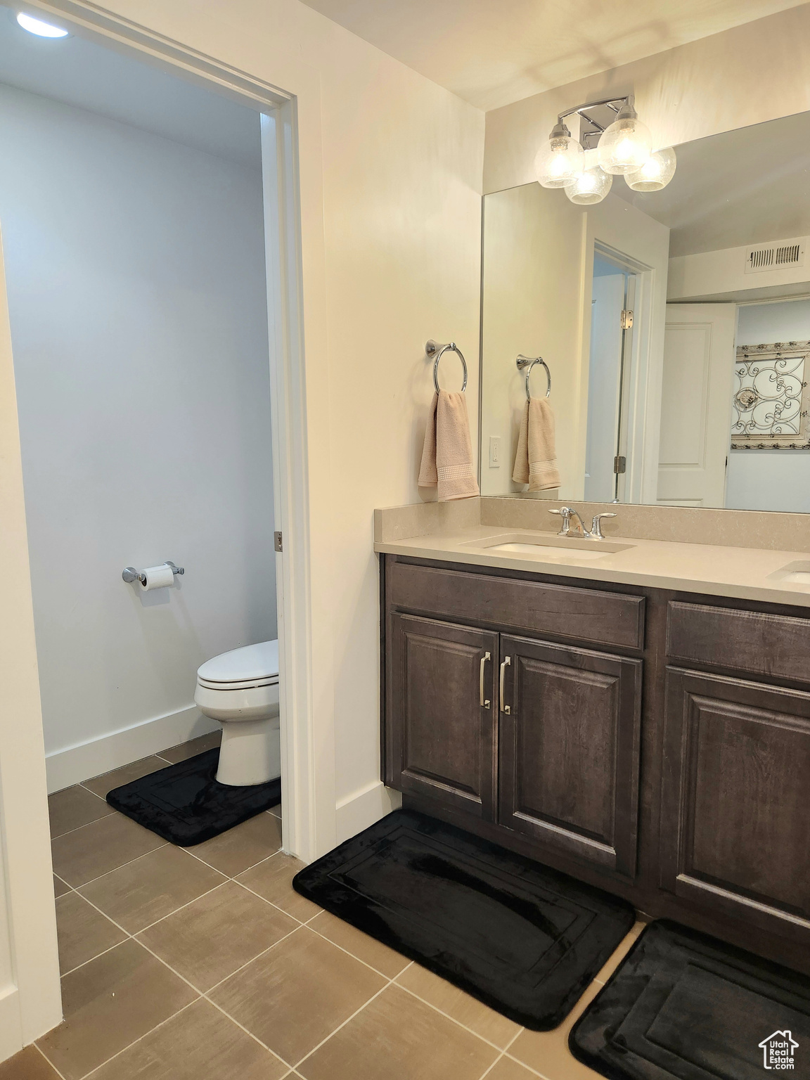 Bathroom featuring vanity, an inviting chandelier, toilet, and tile flooring