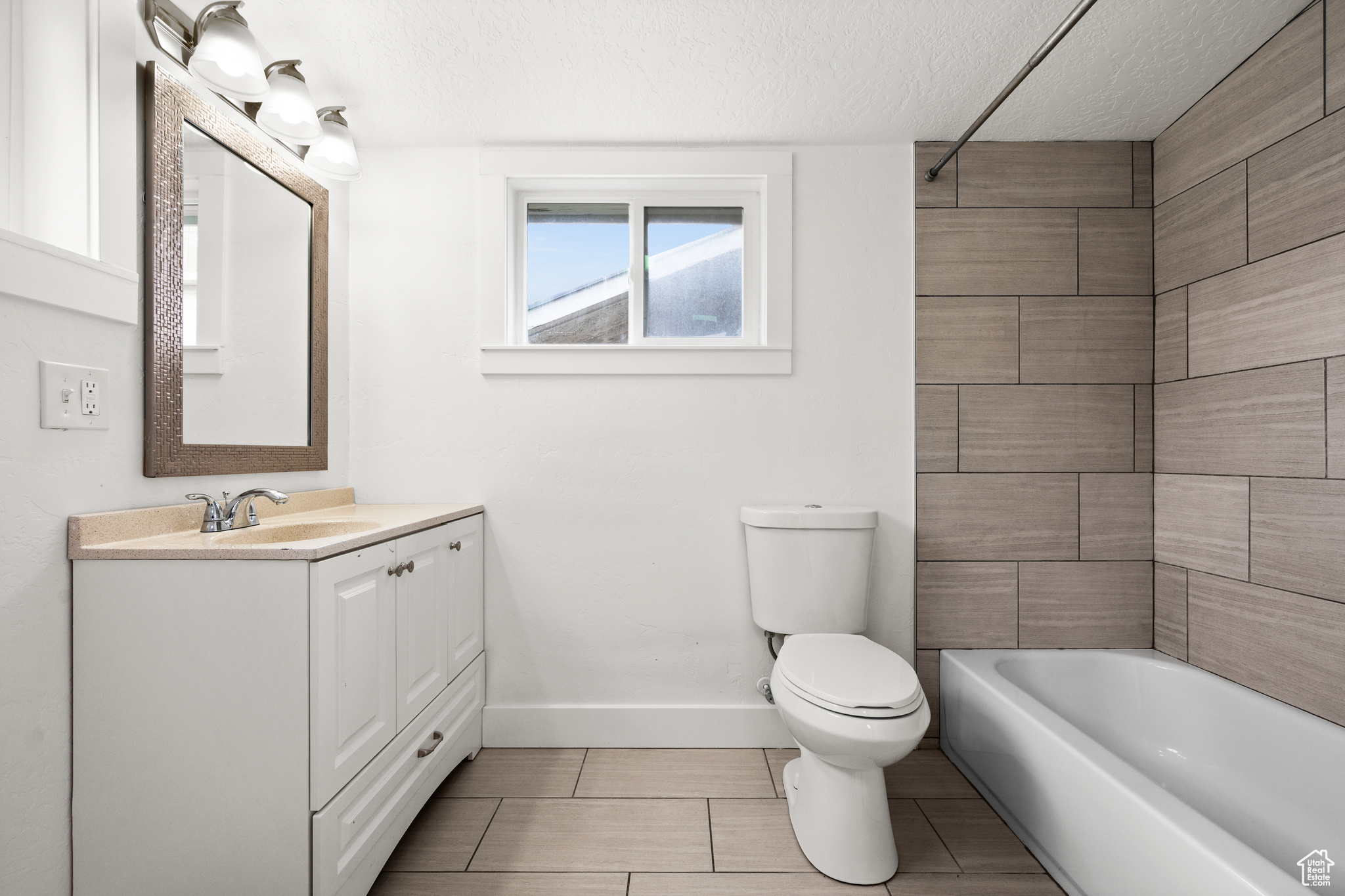 Full bathroom with vanity, shower / washtub combination, a textured ceiling, toilet, and tile floors