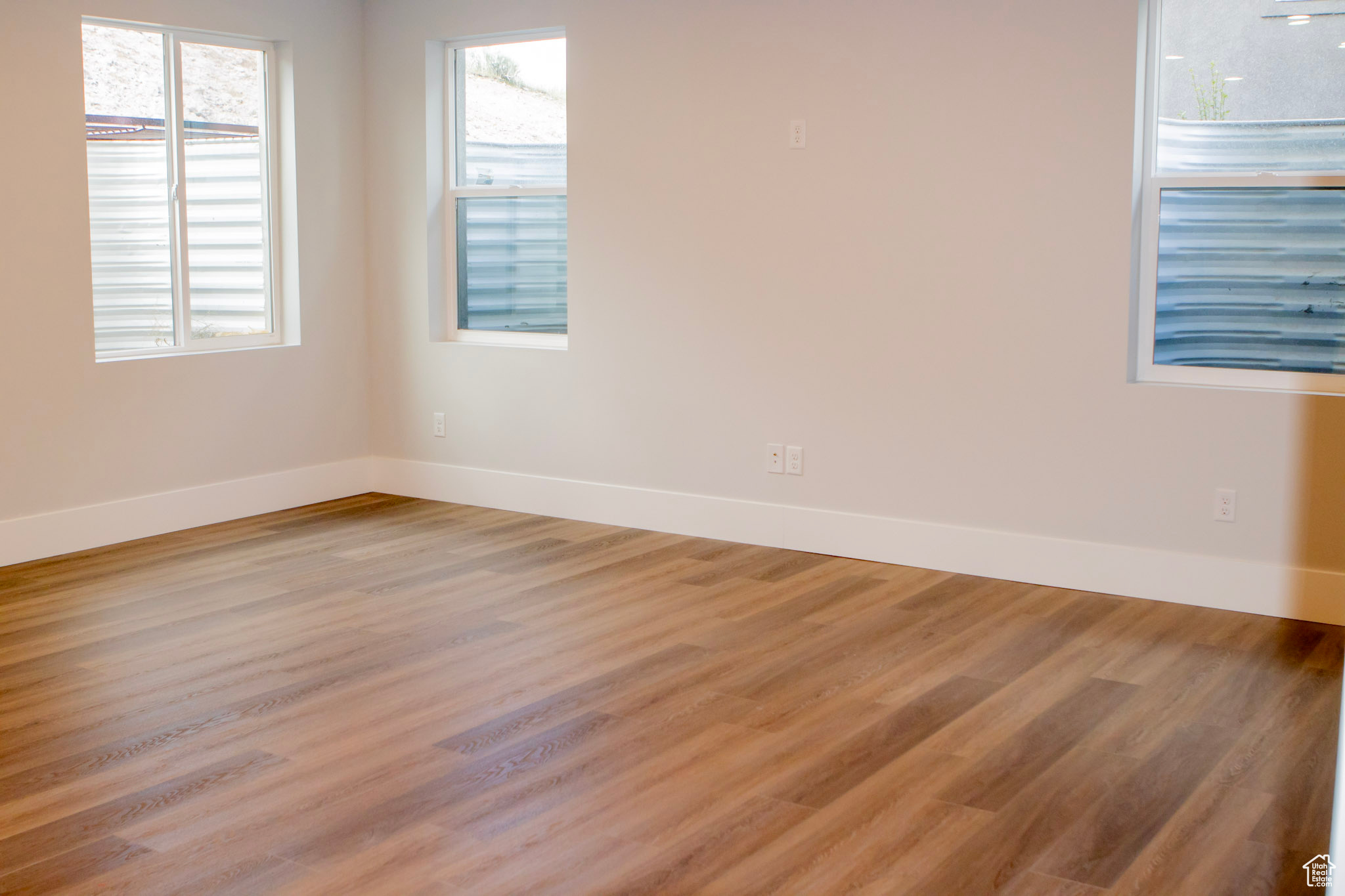 Unfurnished room with plenty of natural light and wood-type flooring