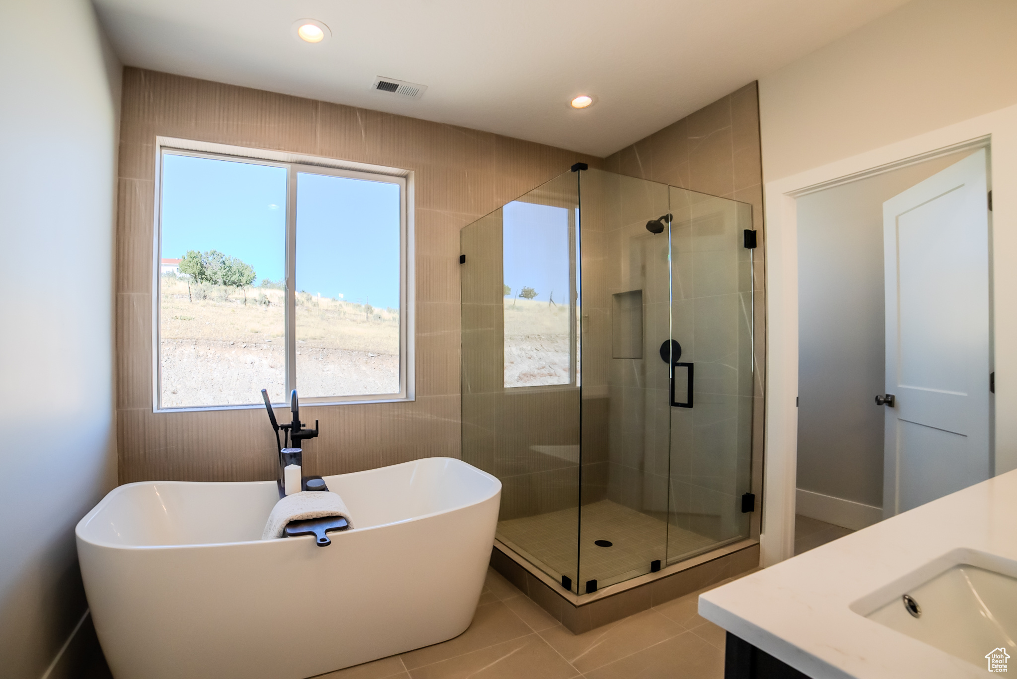 Bathroom featuring shower with separate bathtub, tile patterned flooring, and vanity