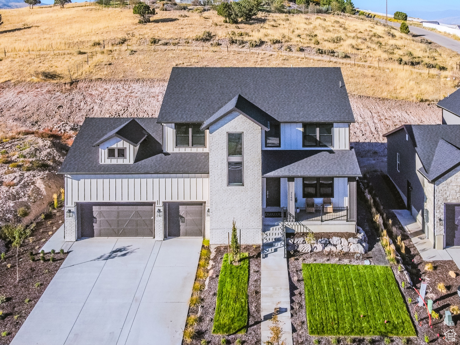 View of front of home with a mountain view, a garage, and covered porch