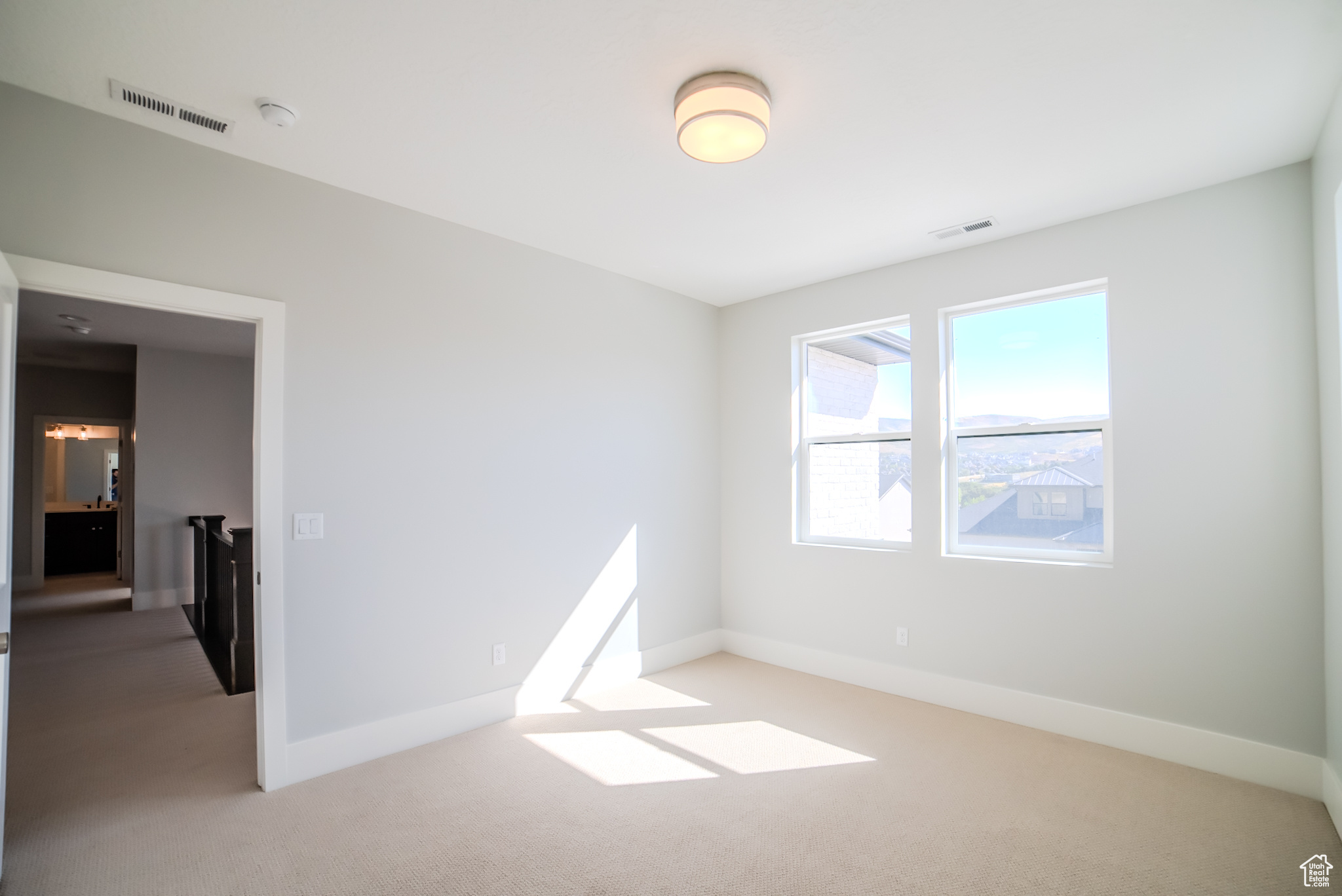 Empty room with light colored carpet