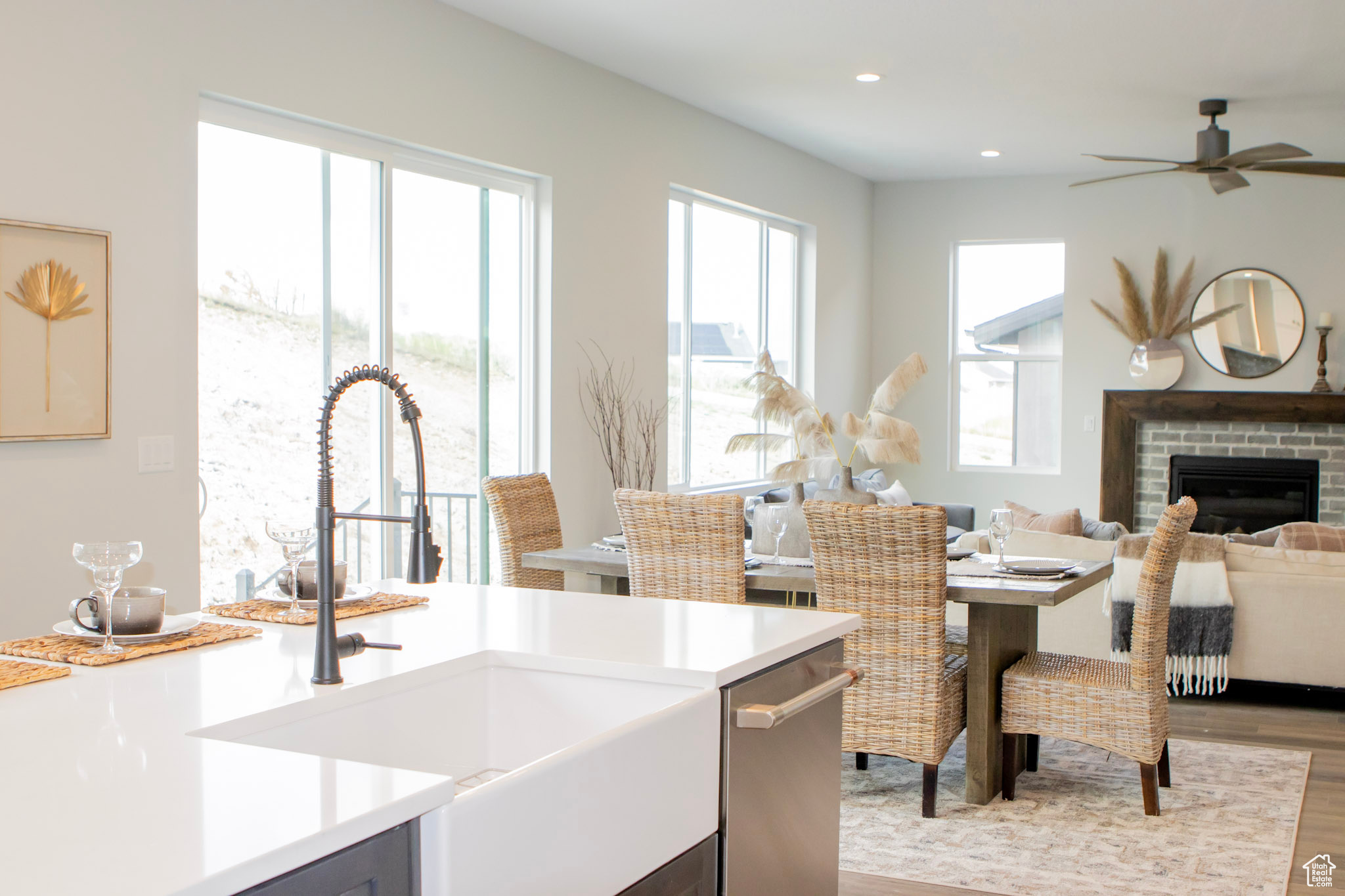 Kitchen featuring ceiling fan, light hardwood / wood-style flooring, a brick fireplace, sink, and dishwasher