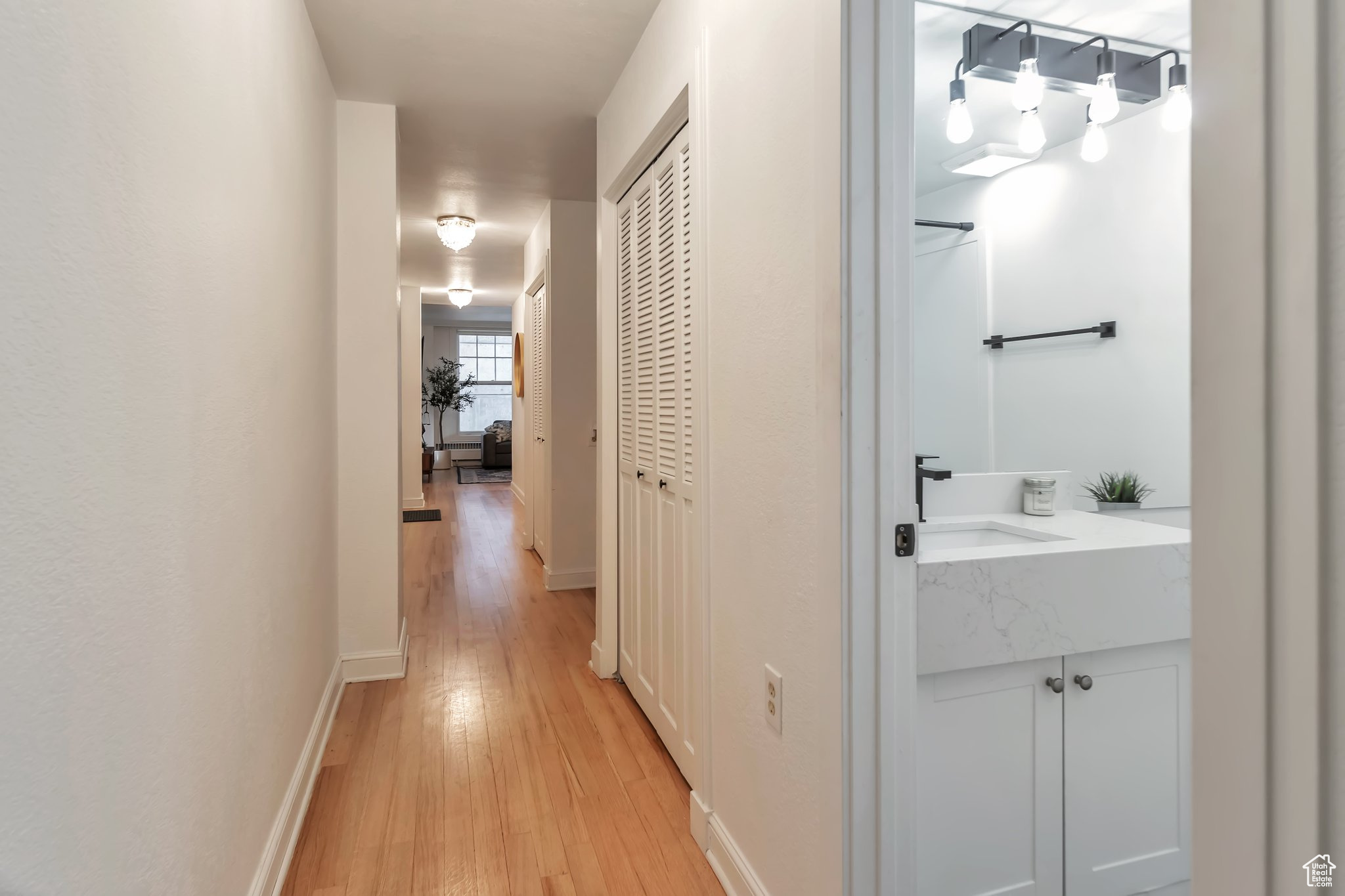 Hallway with sink and light hardwood / wood-style floors