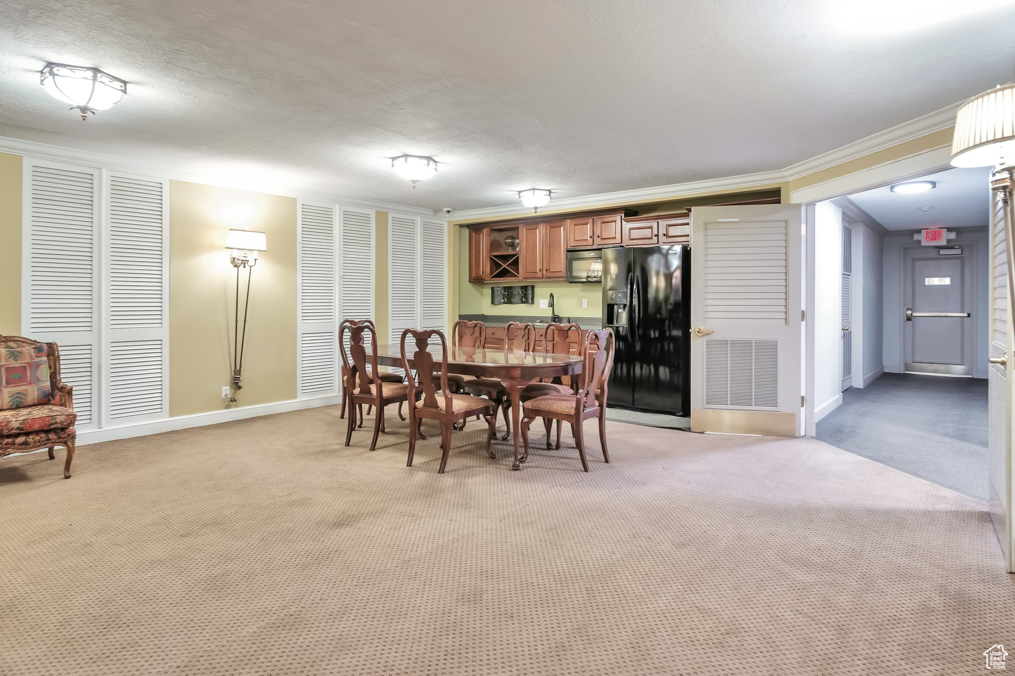 Common area carpeted dining space with ornamental molding