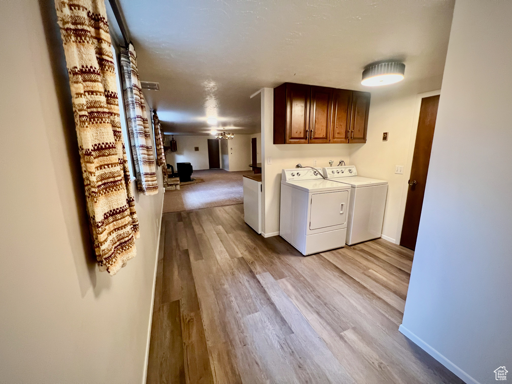 Laundry area featuring ceiling fan, cabinets, light wood-type flooring, and washing machine and dryer