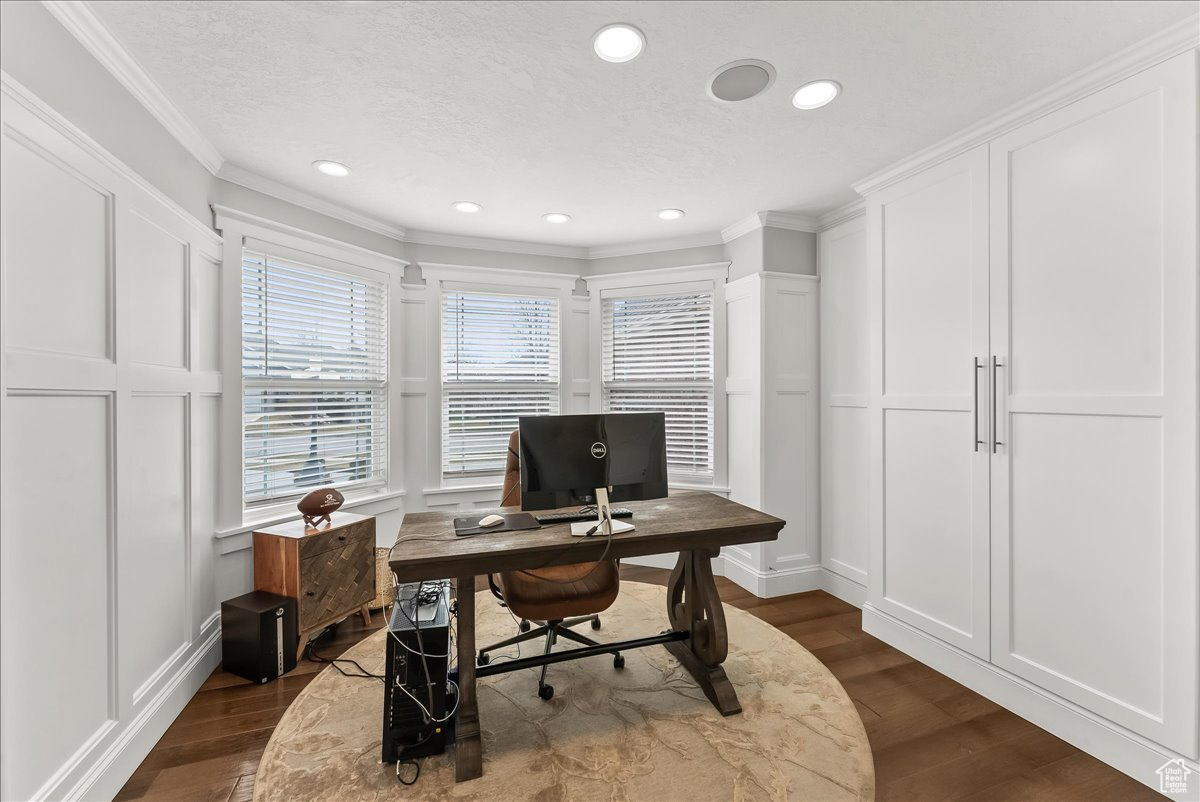 Office with dark hardwood / wood-style flooring and crown molding