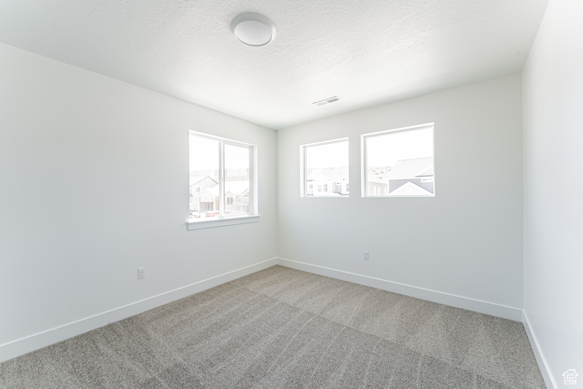 Empty room with carpet flooring and a textured ceiling