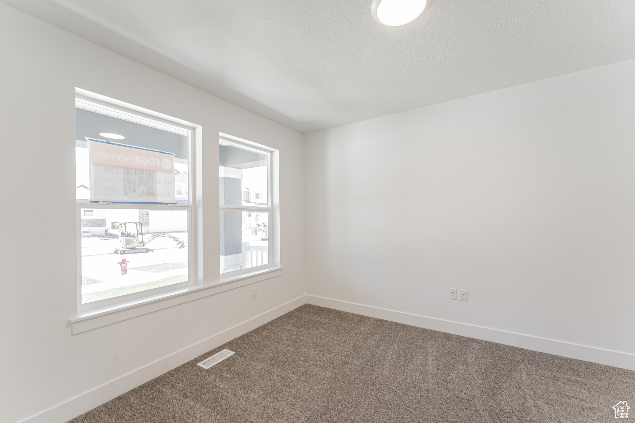 Spare room featuring carpet floors and a wealth of natural light