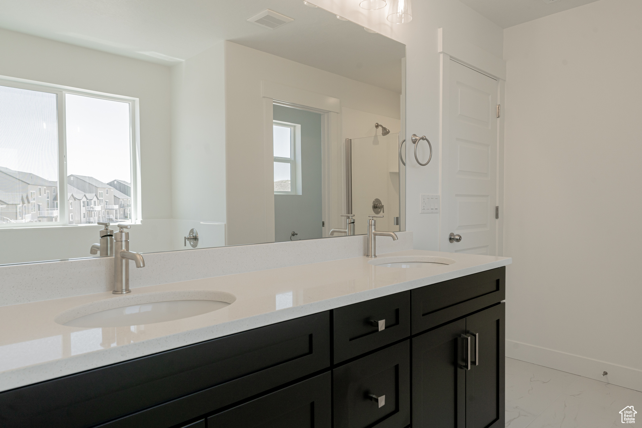 Bathroom featuring tile patterned flooring and double sink vanity