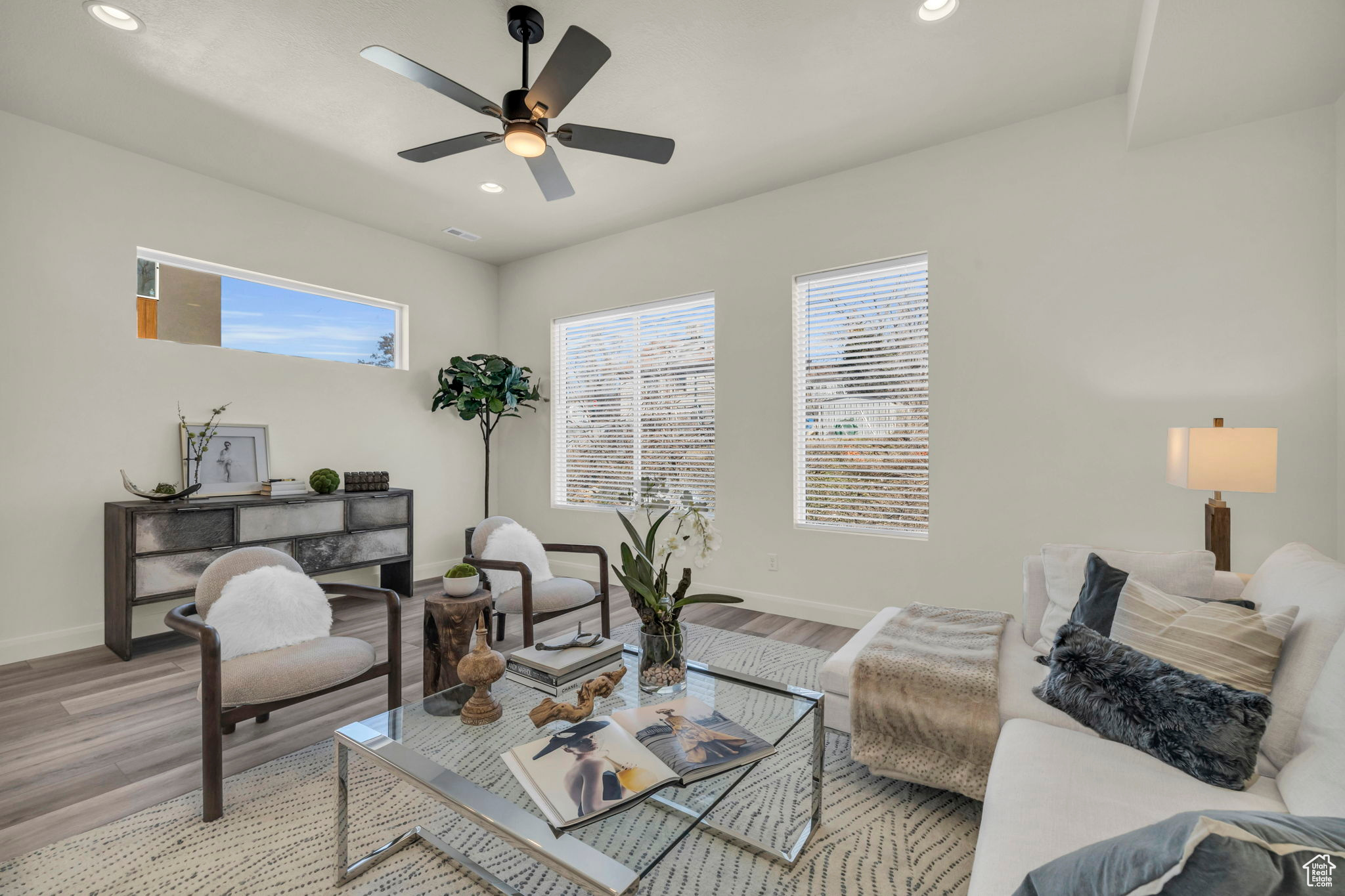 Living room with ceiling fan and light hardwood / wood-style flooring